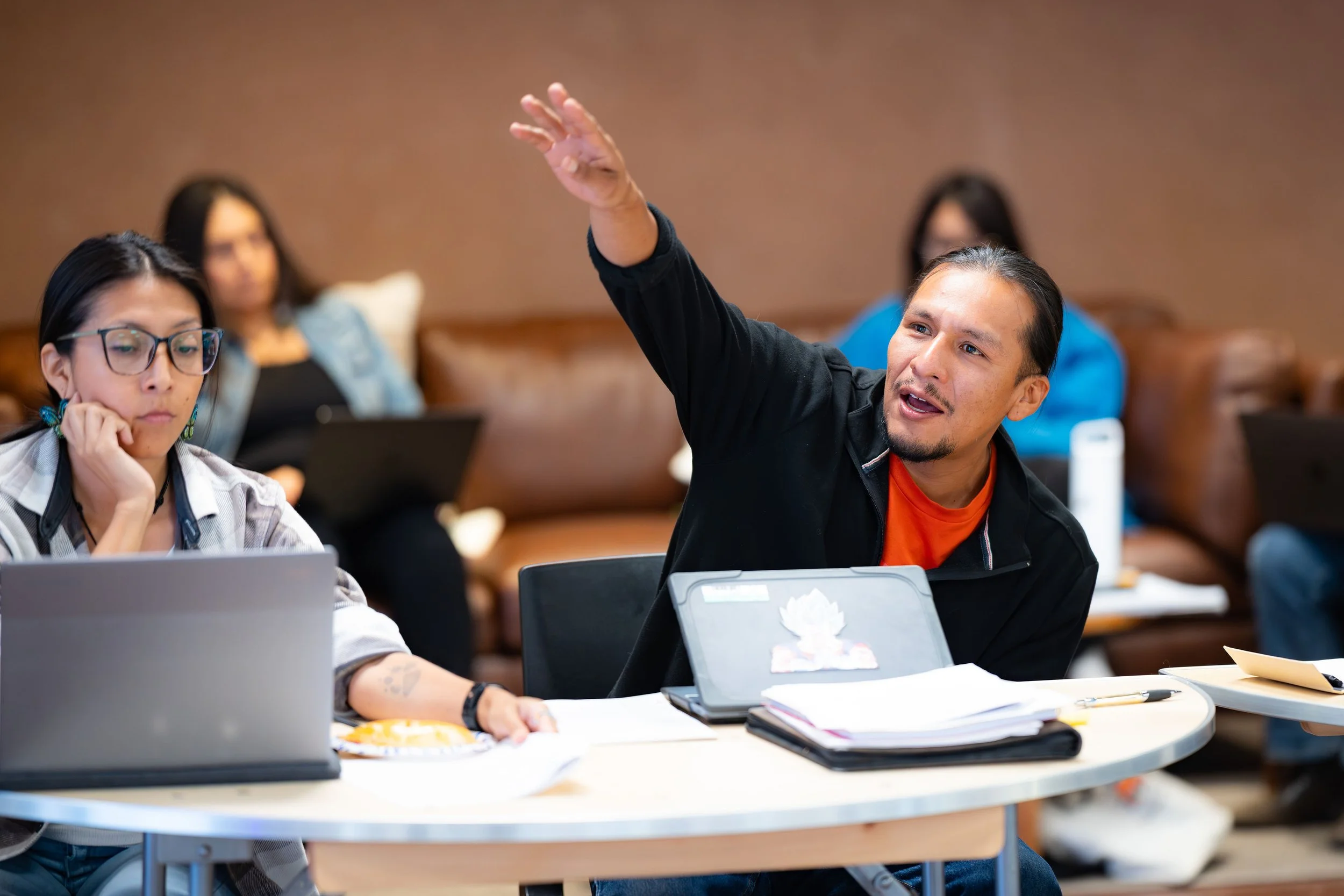 Group of five smiling people standing together in a hallway.
