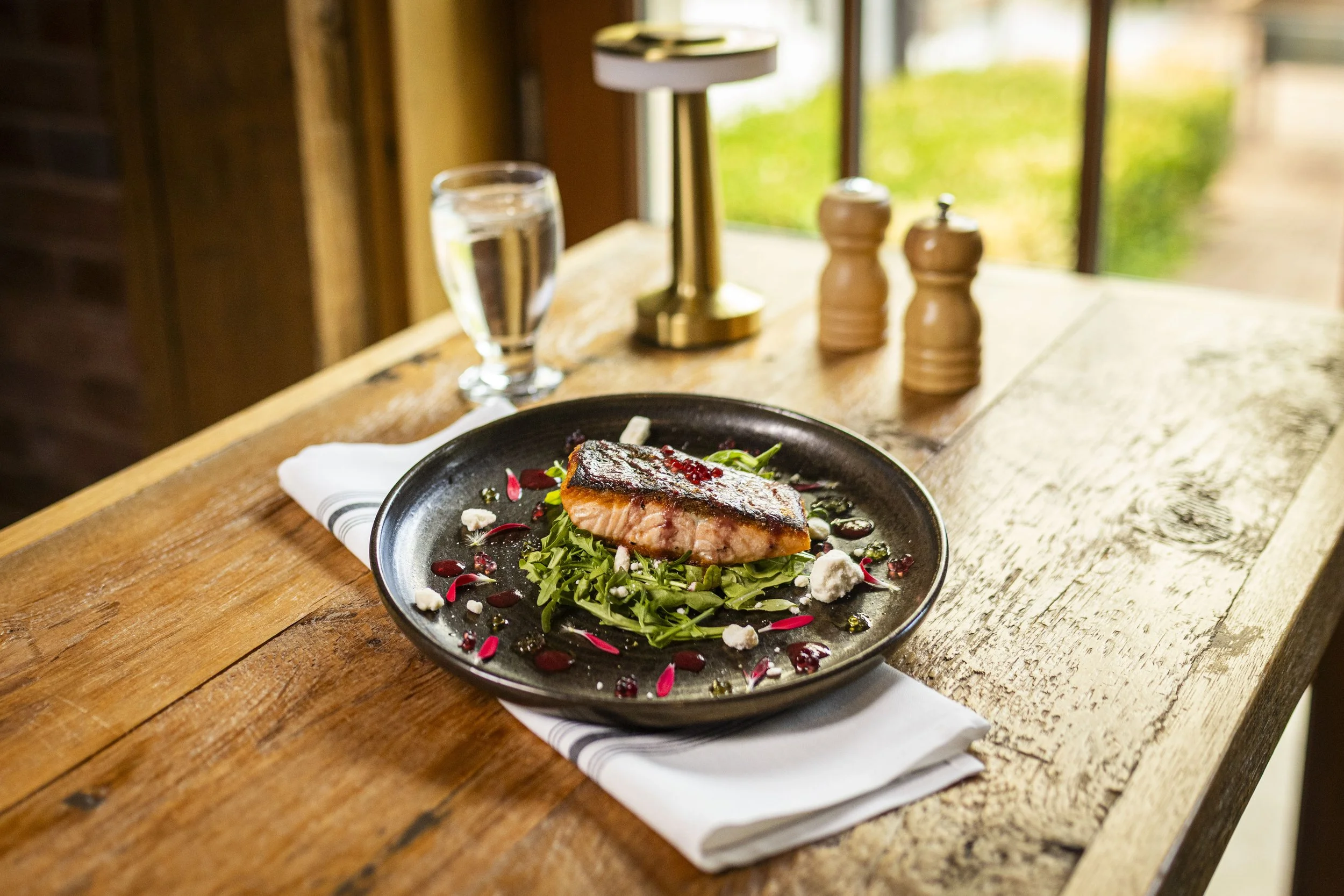 Pan seared salmon with strawberry red wine reduction on arugula topped with feta crumble at Peter Allen Inn