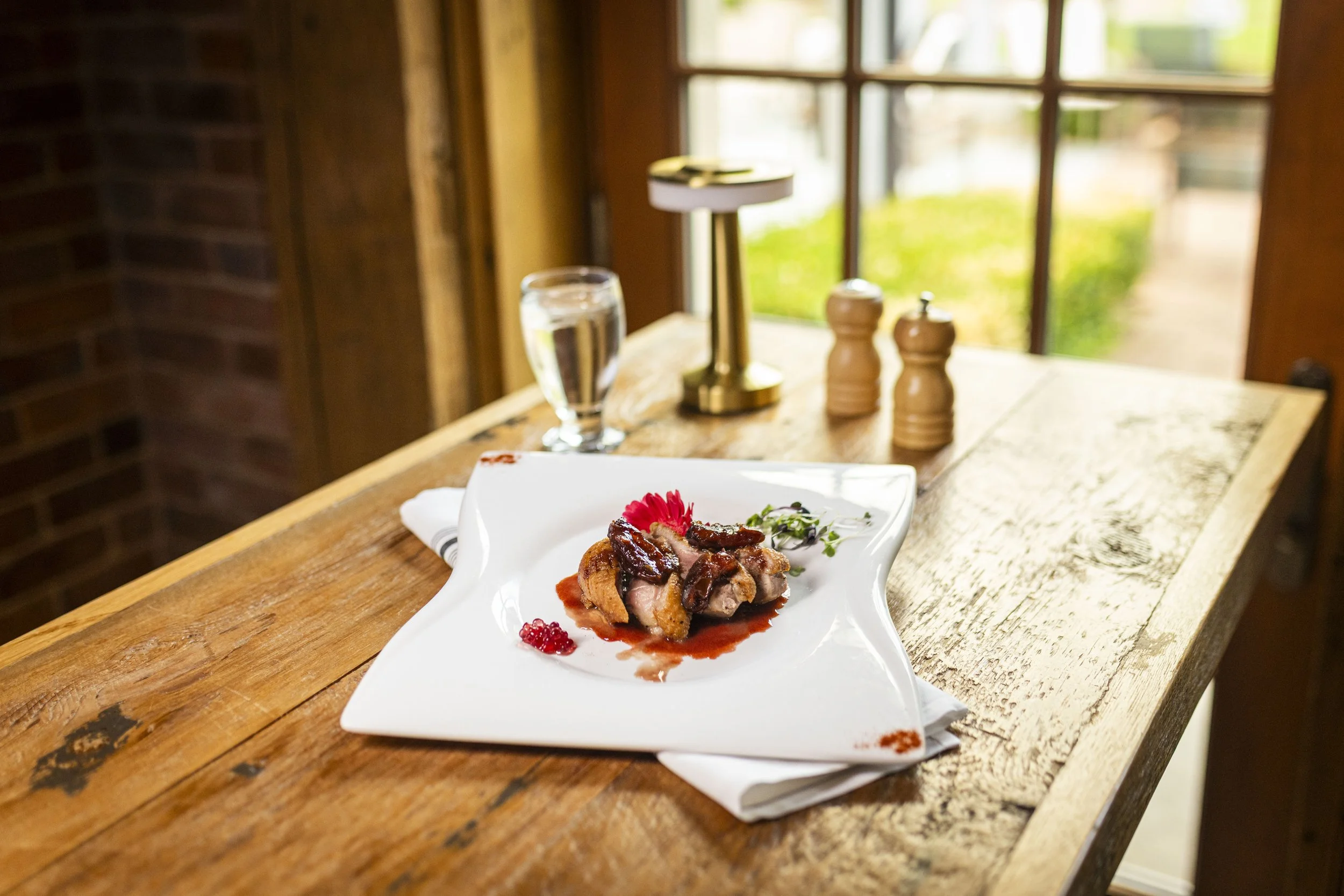 Crispy duck breast with caramelized dates and raspberry red wine reduction on the spring menu at Peter Allen Inn