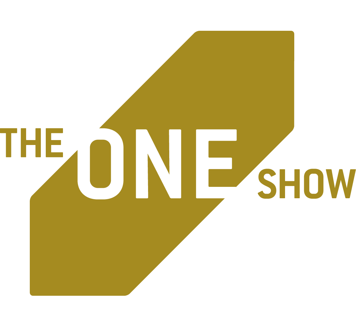 Logo for 'The One Show' featuring black text and a gold geometric shape background.