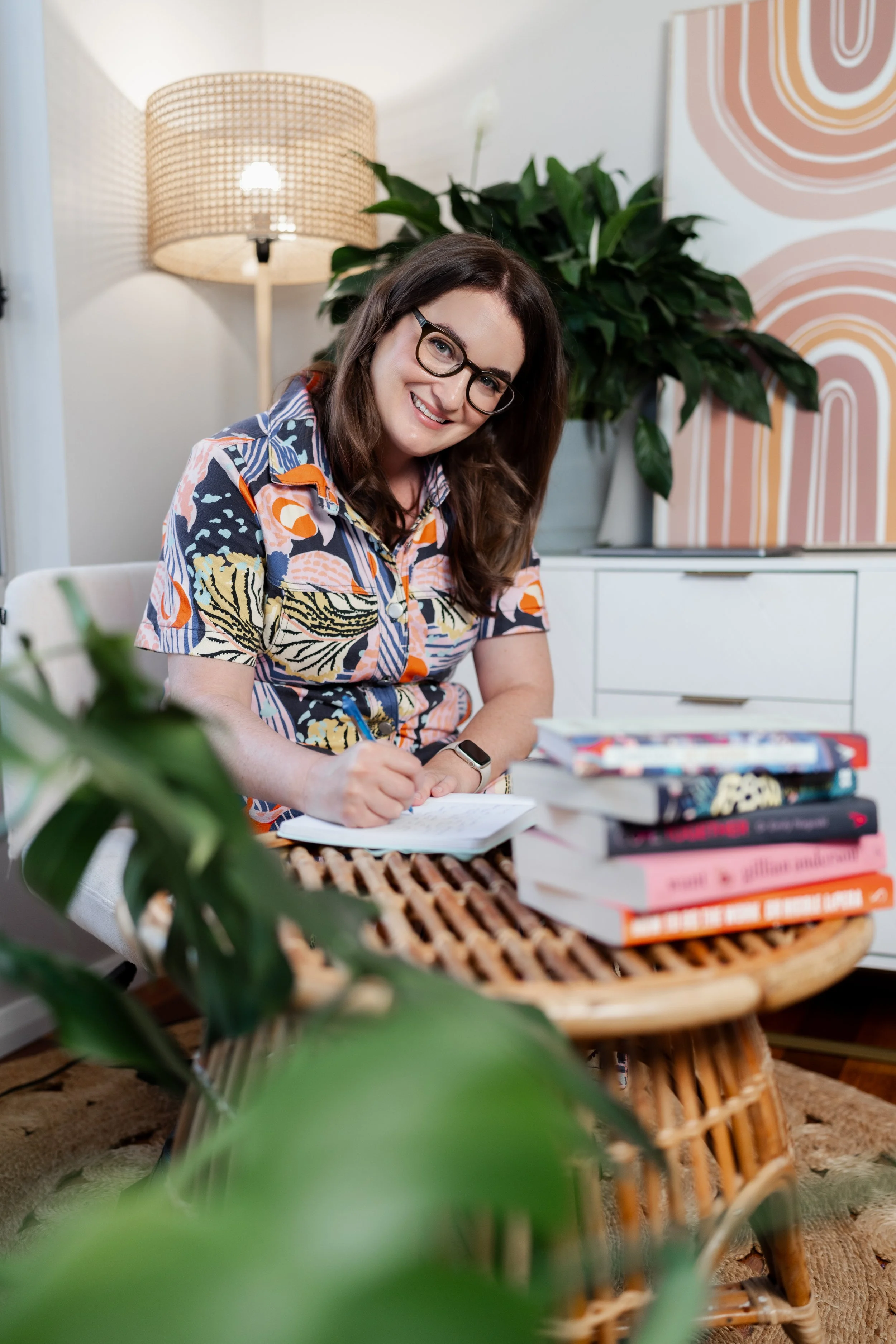 Gabrielle, couples therapist, smiling at her desk in her Fairy Meadow therapy room