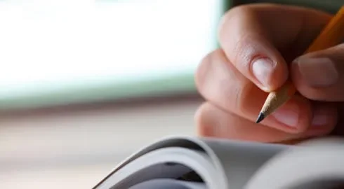 A hand writing with a pencil