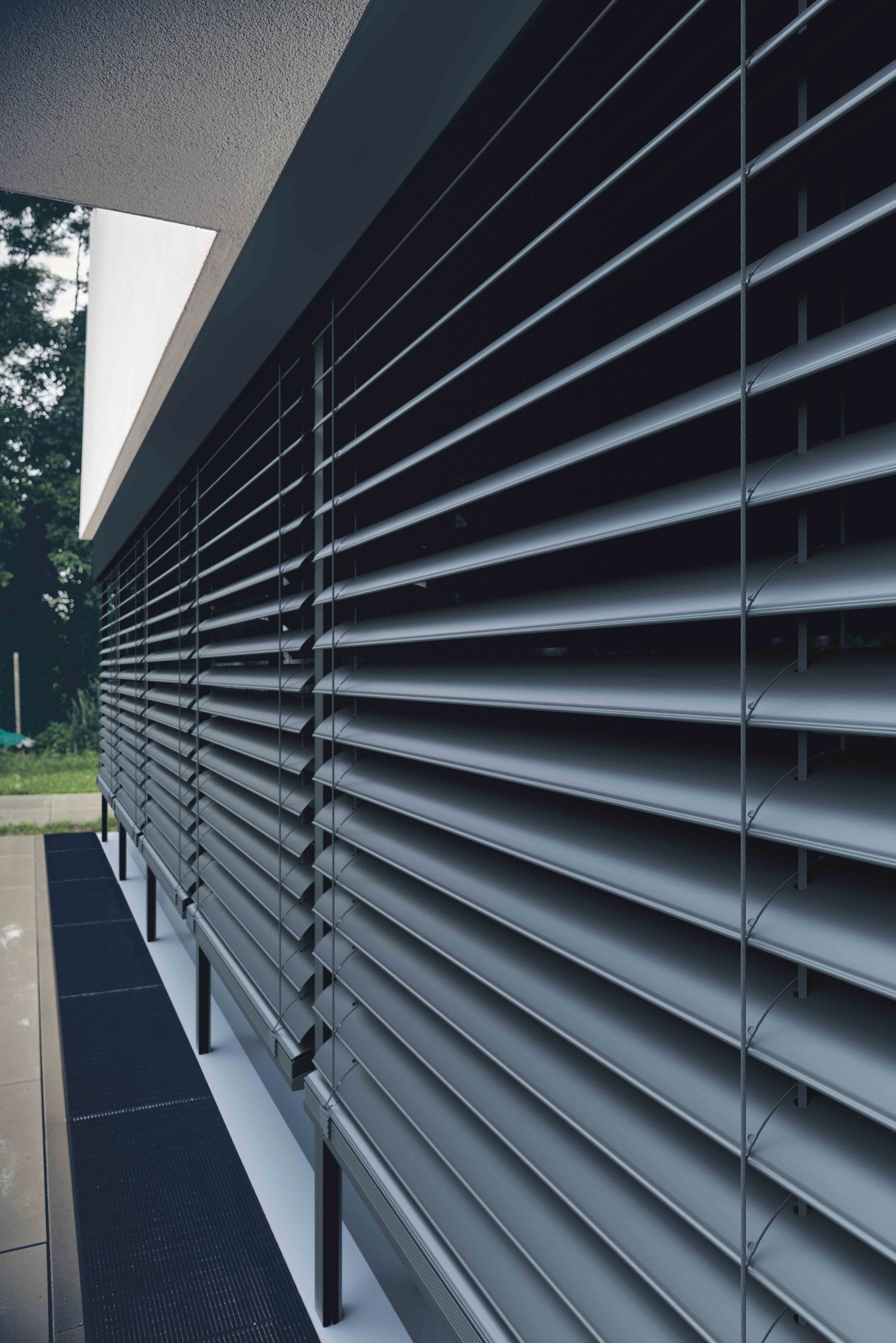 Moderne Gebäude mit horizontalen Aluminium-Lamellen als Sonnenschutz.