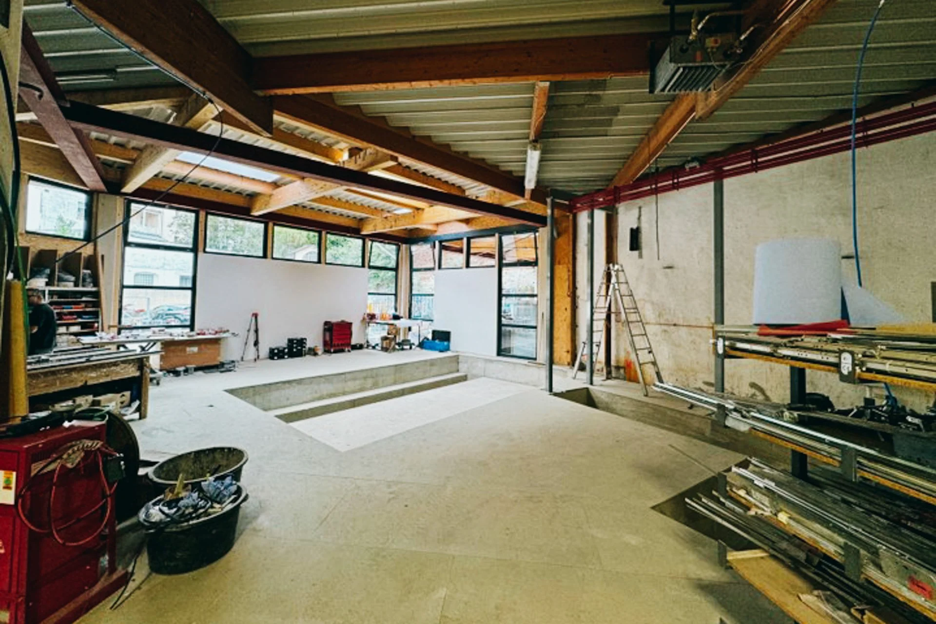 Innenansicht eines Bau- oder Renovierungsprojekts mit Holzstruktur, Werkzeuge und Baustoffe.