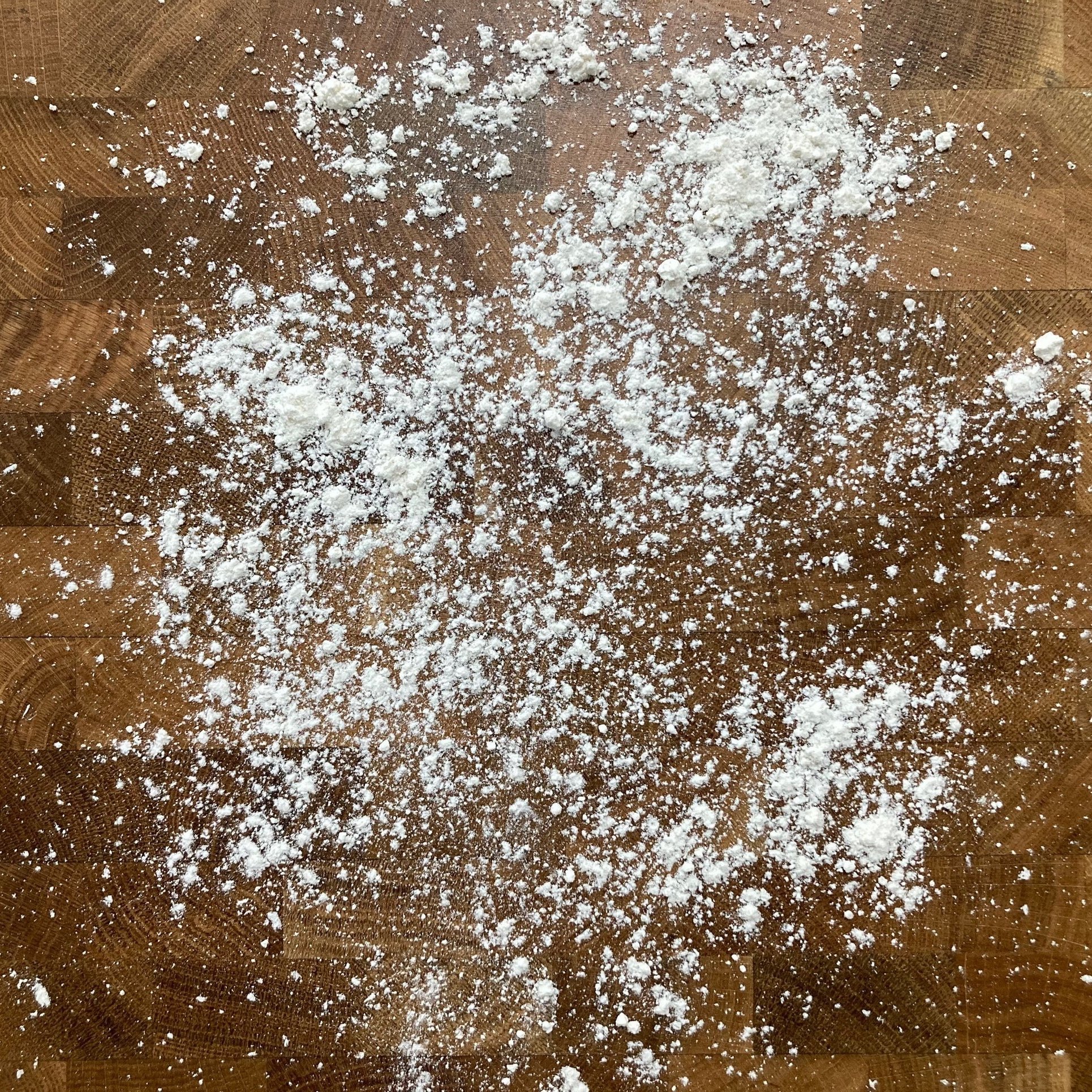 Flour scattered on a wooden surface.