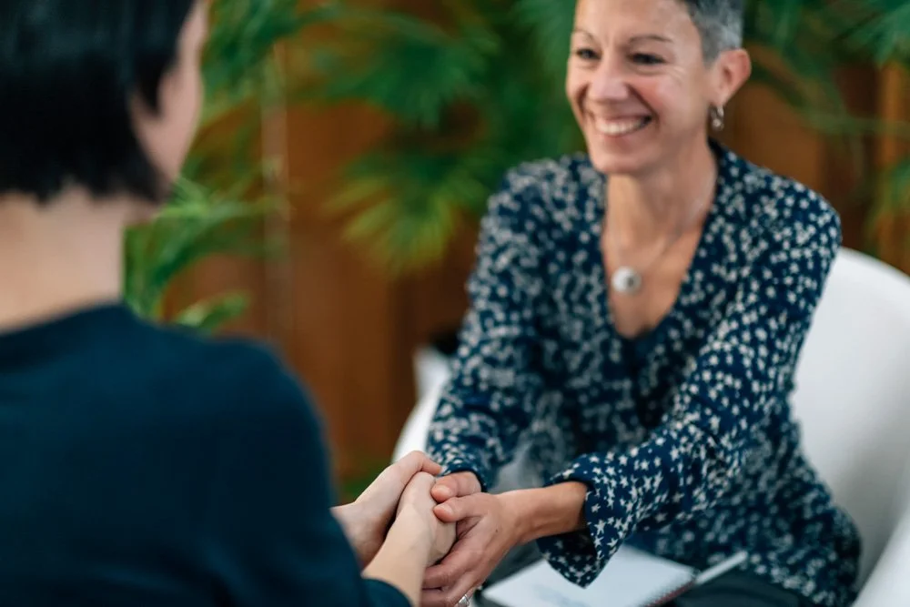 Therapist holding the hands of a client.