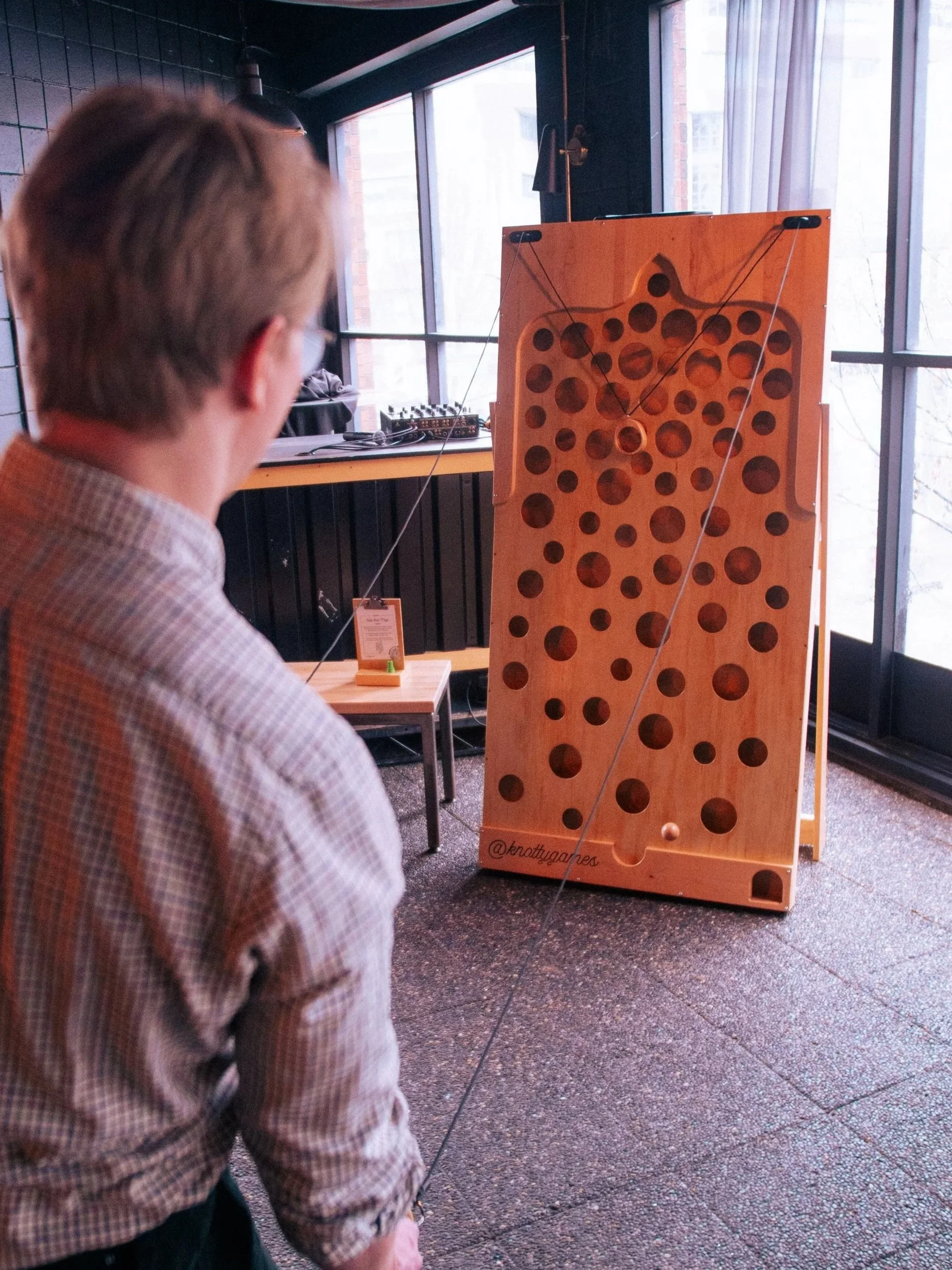 Man plays Wall Maze in the corner of a room