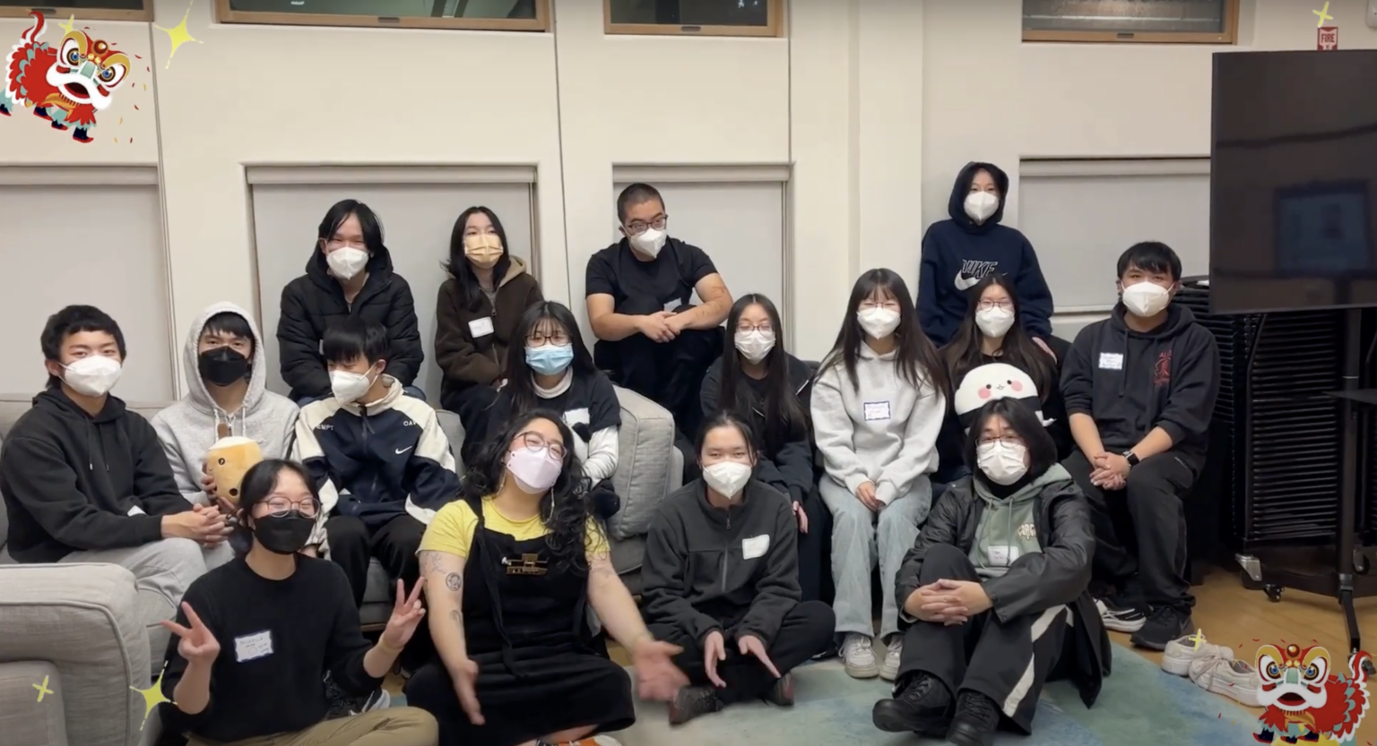Approximately 15 Youth MOJO members sit on the floor, posing for a group picture.