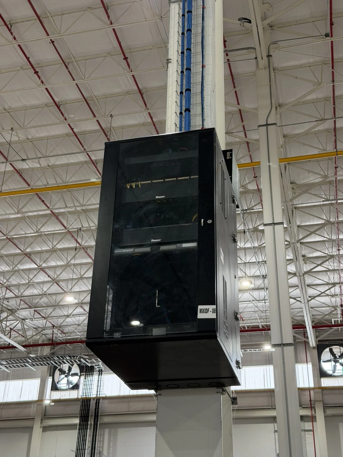 Rack de telecomunicaciones con cableado estructurado en instalación industrial.