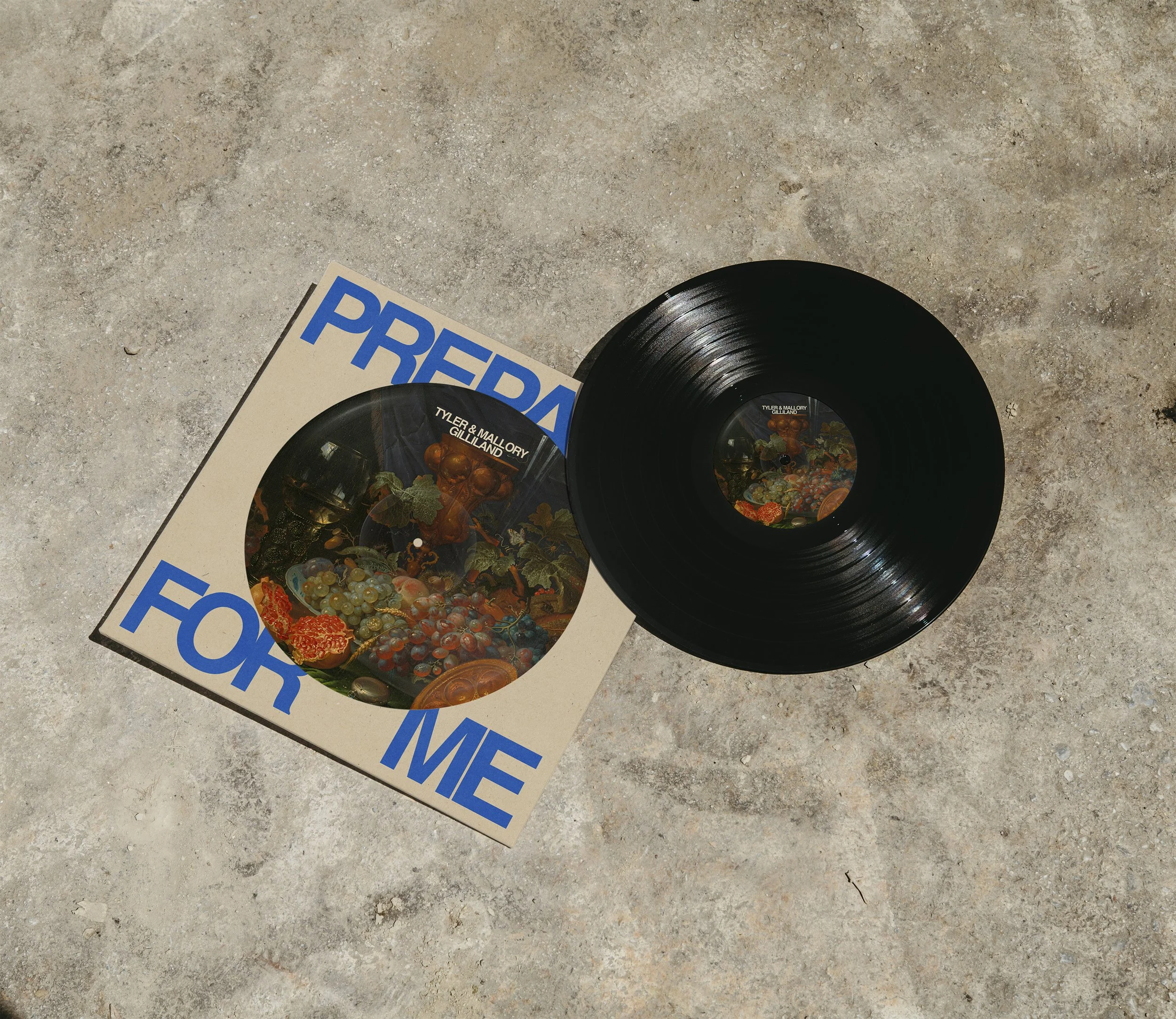 A vinyl record and its album cover resting on a textured concrete surface. The album cover features the title 'Pre-For Me' in large blue letters and displays colorful fruit and vegetables.