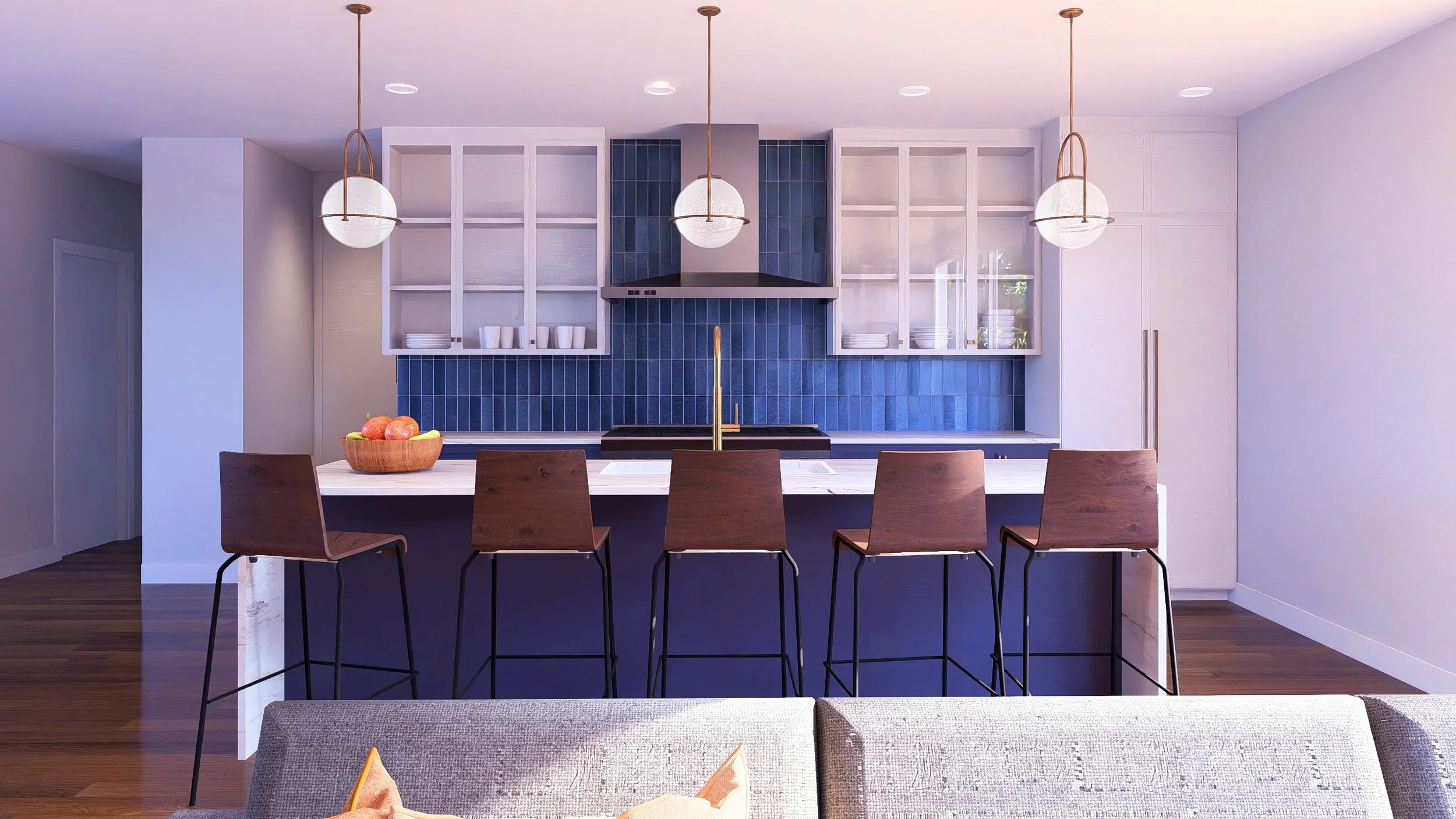 Modern kitchen with white cabinets, a navy blue tiled backsplash, a white island with a marble top, five wooden bar stools, and three hanging pendant lights. A fruit bowl with apples sits on the island.