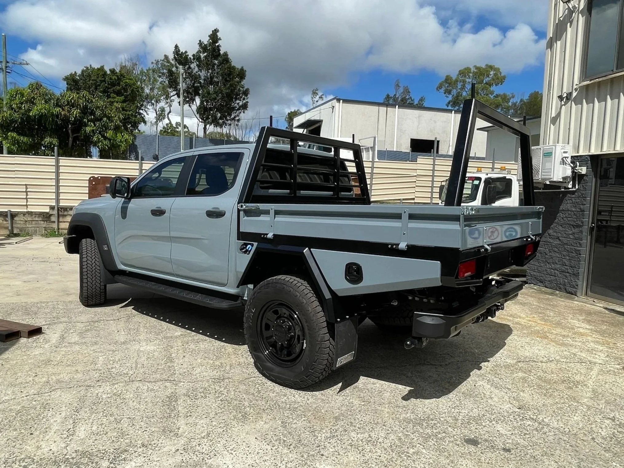 A Ford Super Duty straight from the dealership for a custom colour-coded aluminium tray for a tradie. Fit with double-tapered toolboxes and rear trundle draw.
