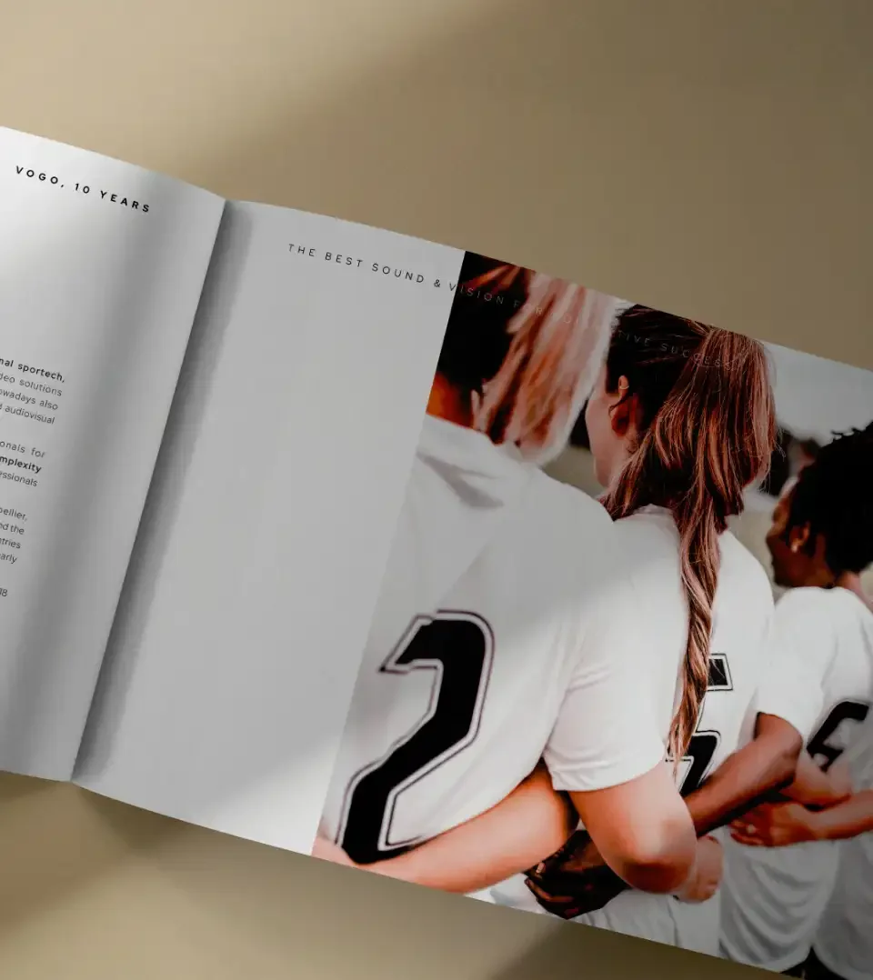 Livre de marque ouvert sur une photographie d’équipe féminine illustrant la cohésion et l’ambition collective