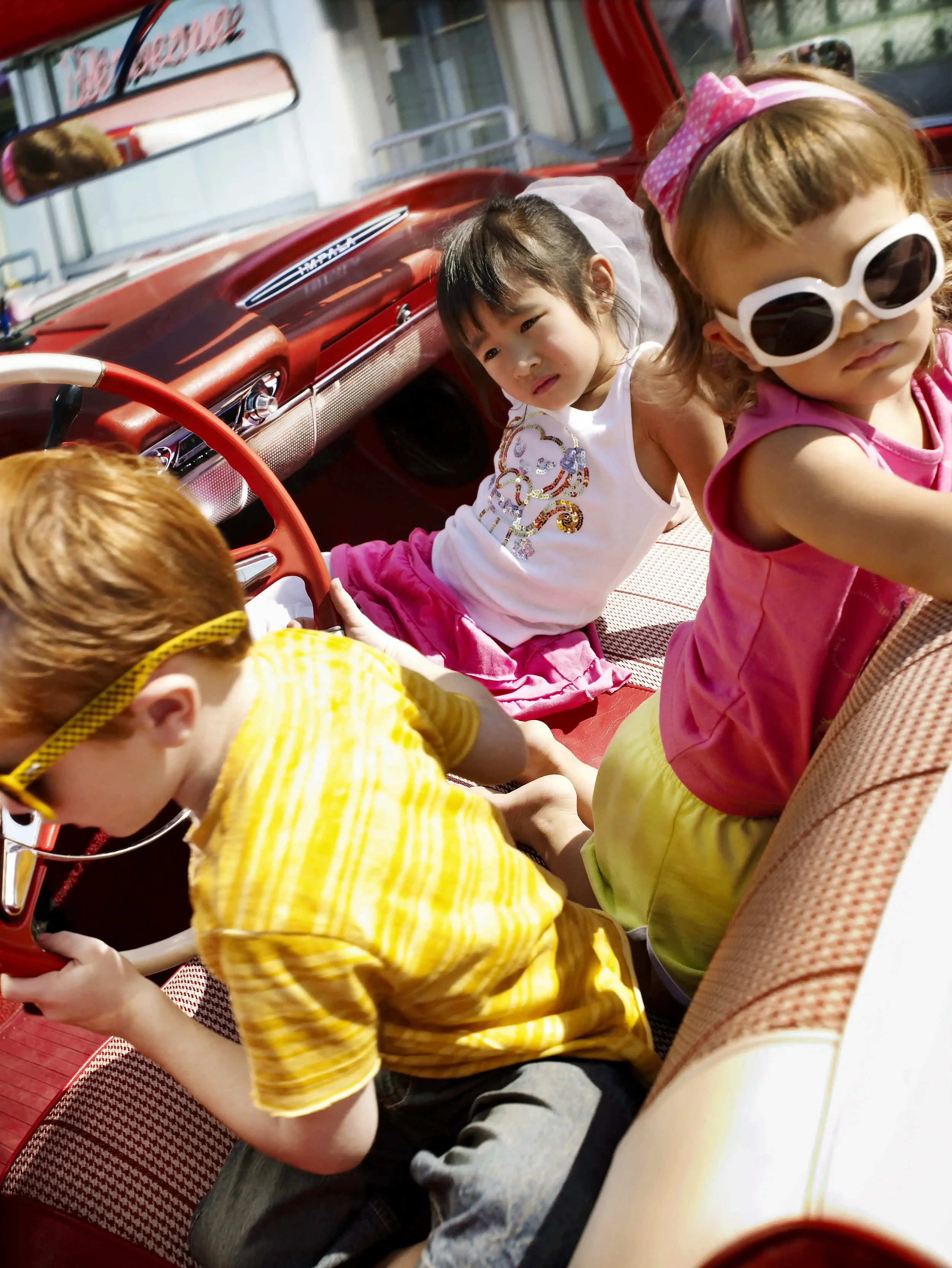 Enfants stylés dans une voiture vintage illustrant le storytelling road trip de la campagne photo Orchestra