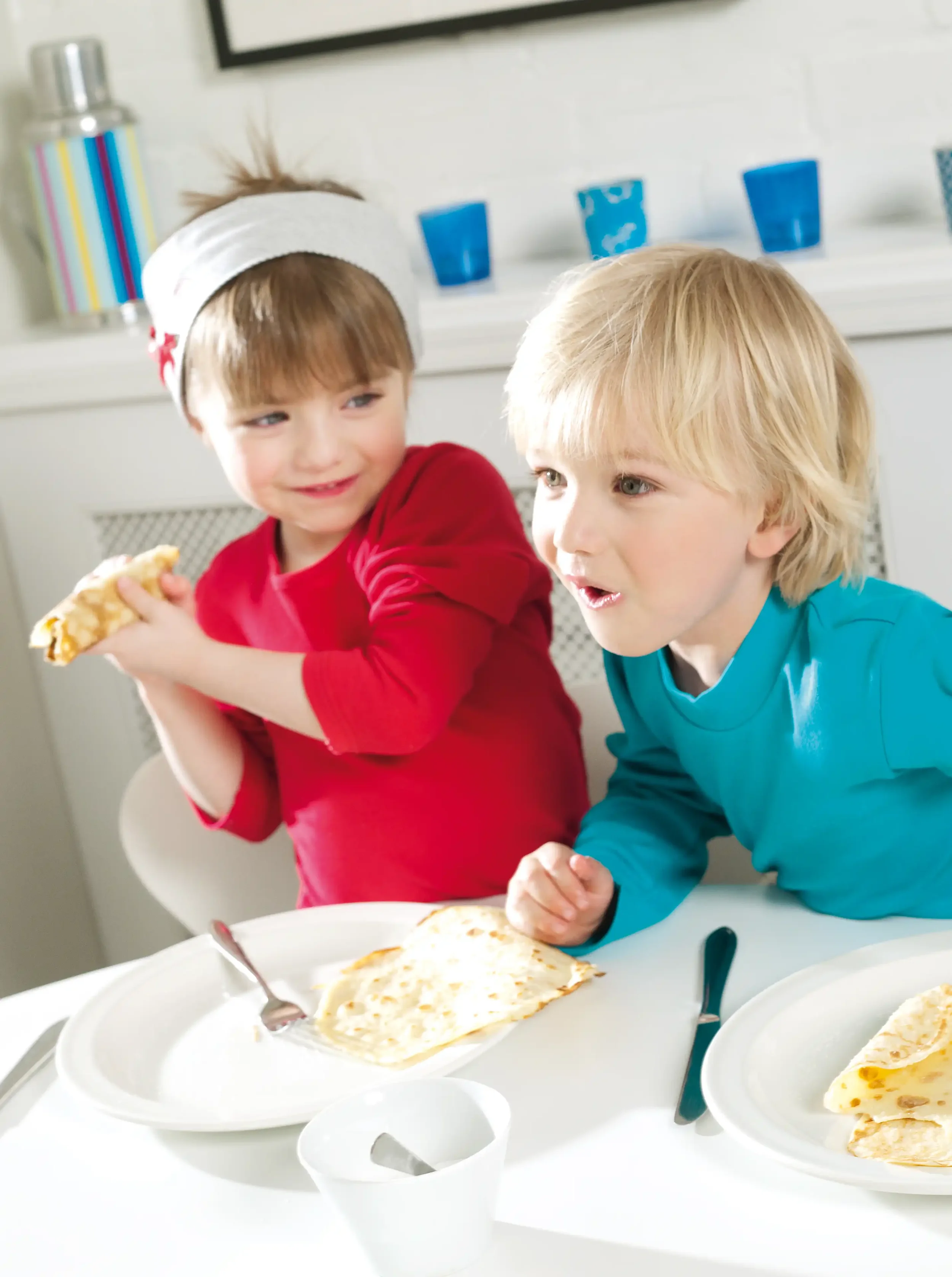 Deux enfants riant autour de crêpes illustrant la spontanéité et la complicité