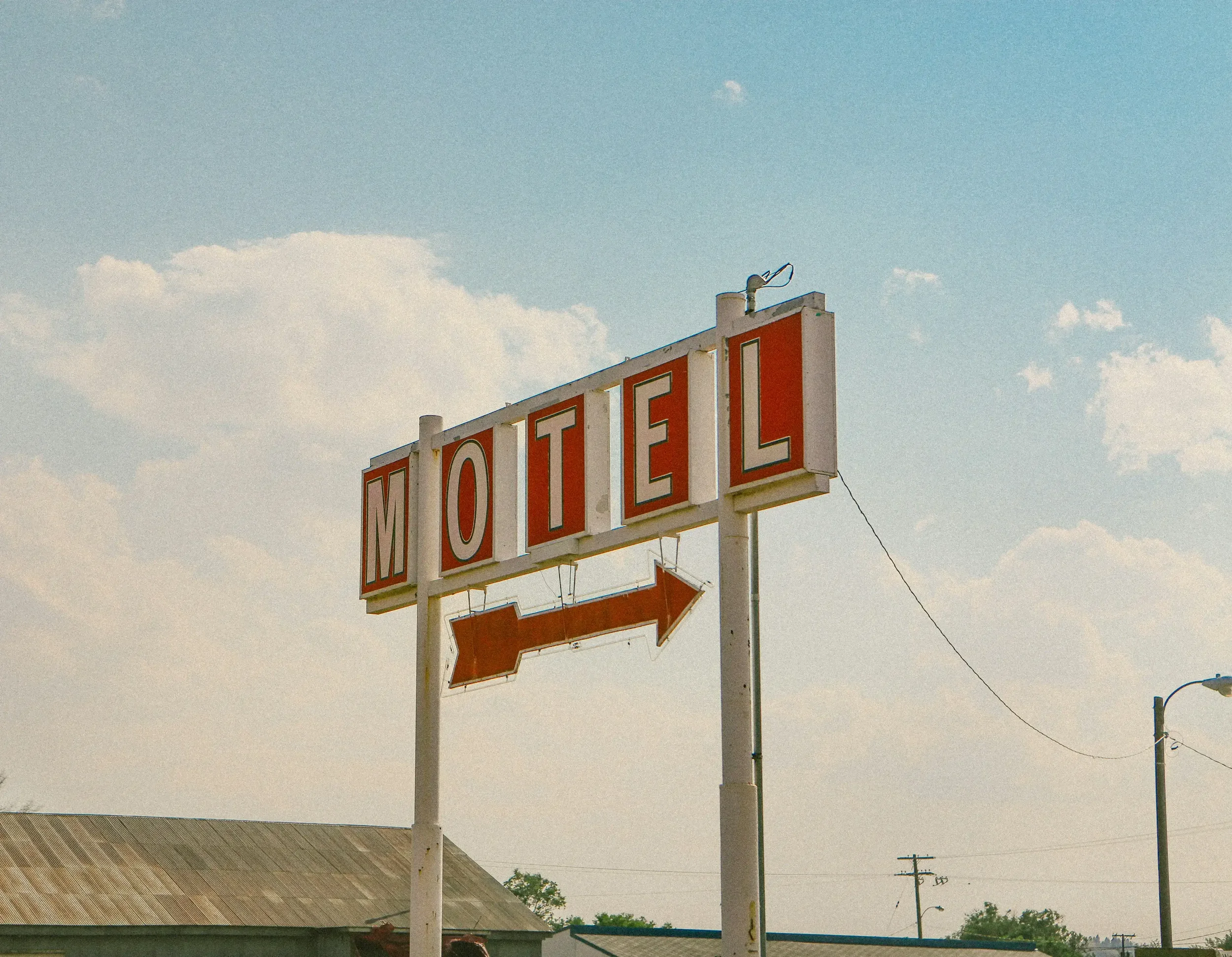 Enseigne de motel avec une flèche symbolisant l'univers du roadtrip de la campagne éditoriale