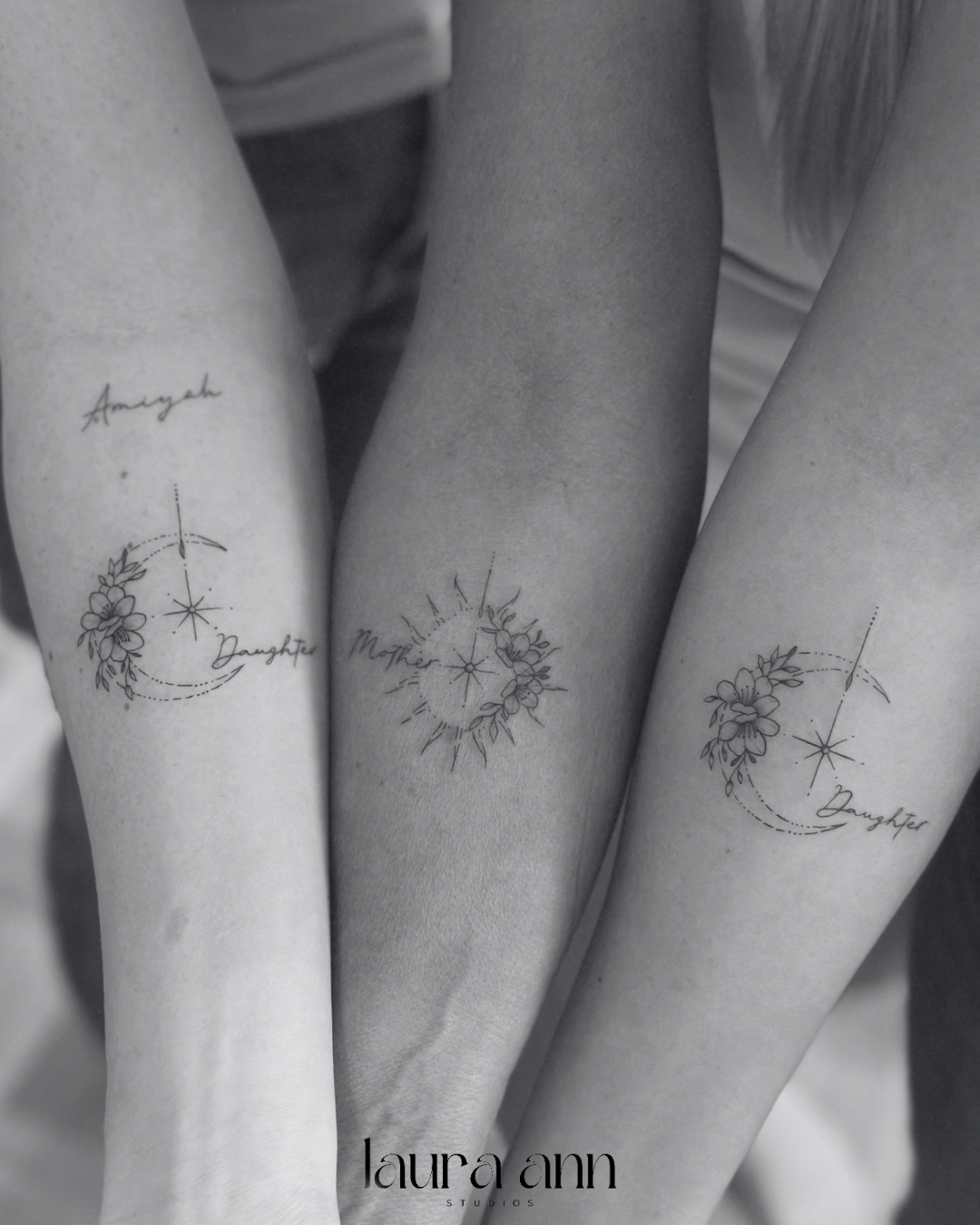 Three forearms with matching tattoos featuring stars, flowers, and the words "Mother" and "Daughter."