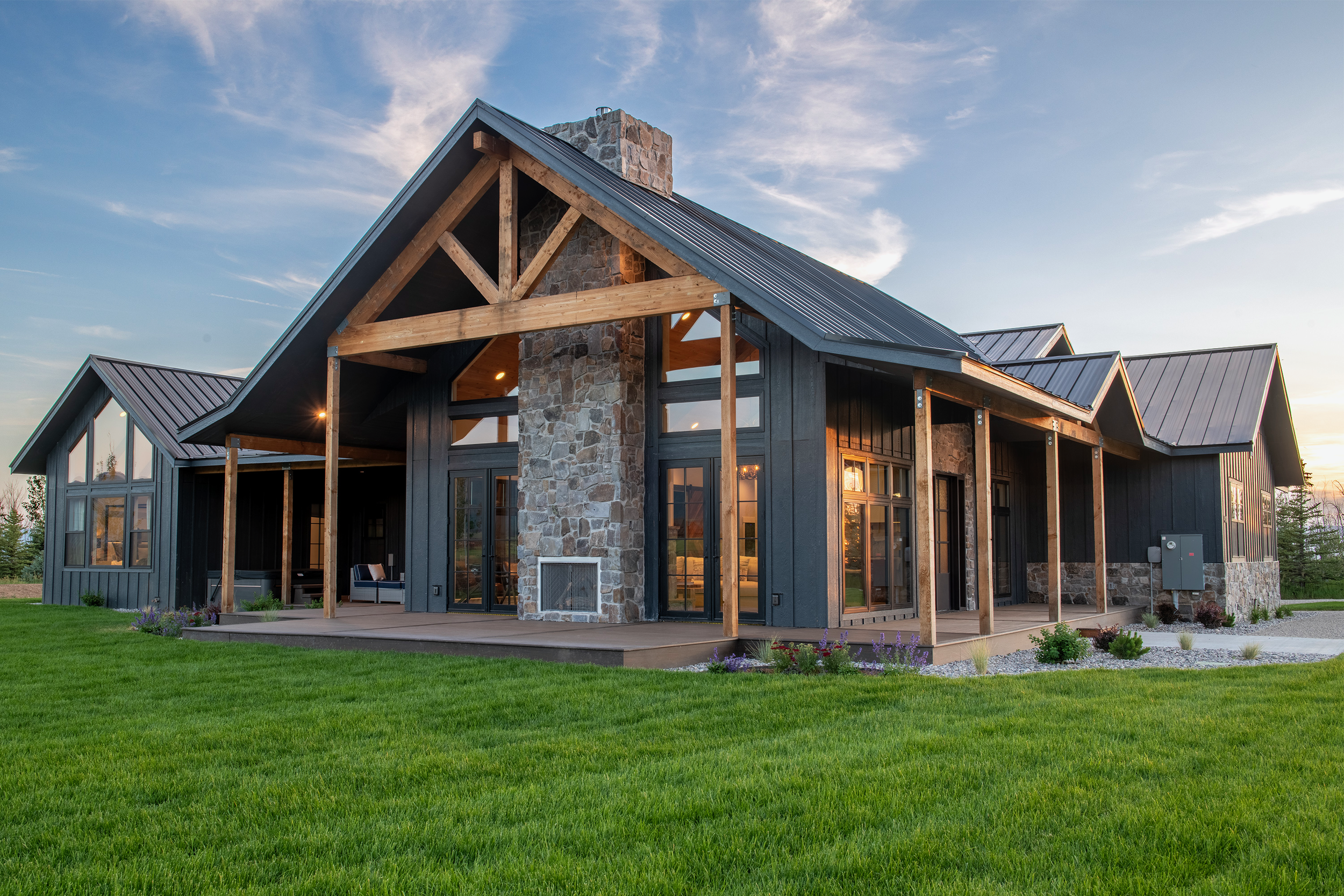 Spacious backyard with outdoor games area, wraparound deck, hot tub, and dining space at 5-bedroom vacation rental near Jackson Hole and Grand Targhee