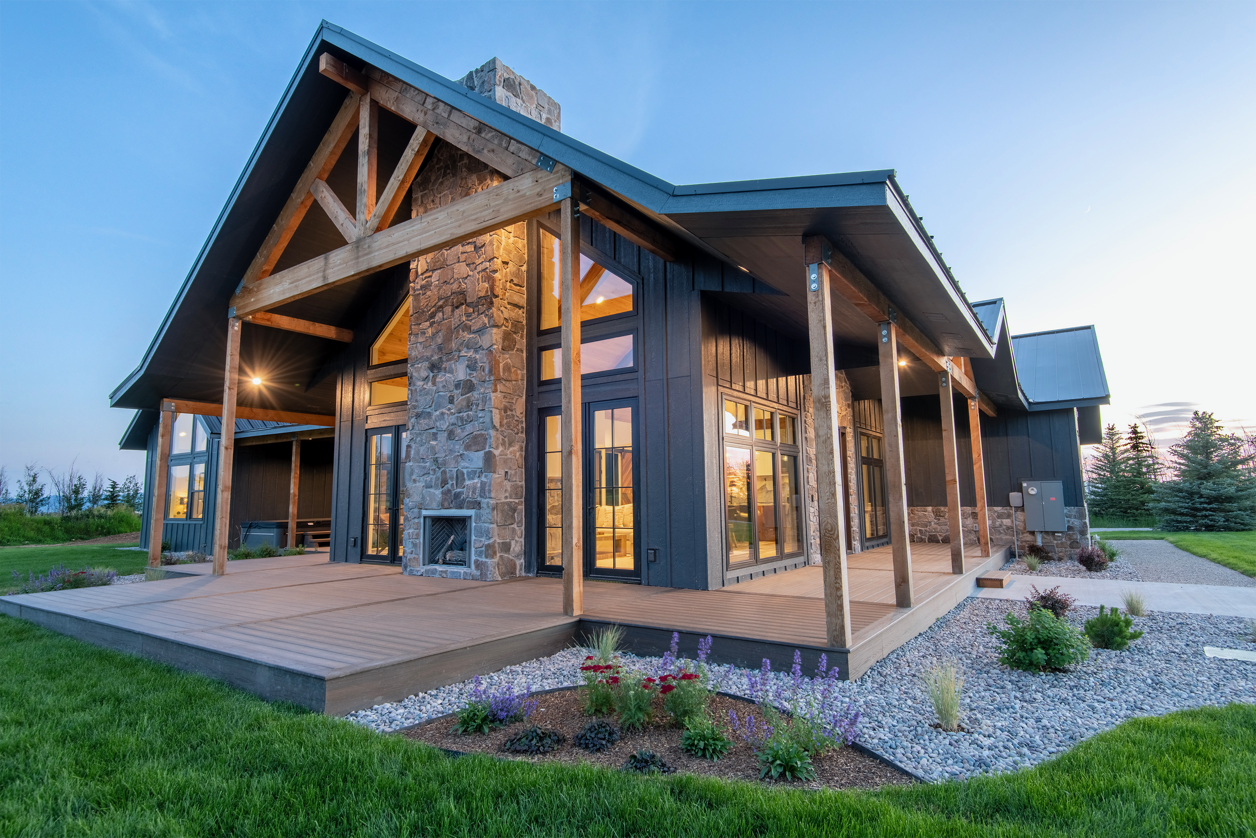 Backyard with stunning views of the three Teton peaks, wraparound deck, and lush landscaping at vacation home near Grand Teton National Park