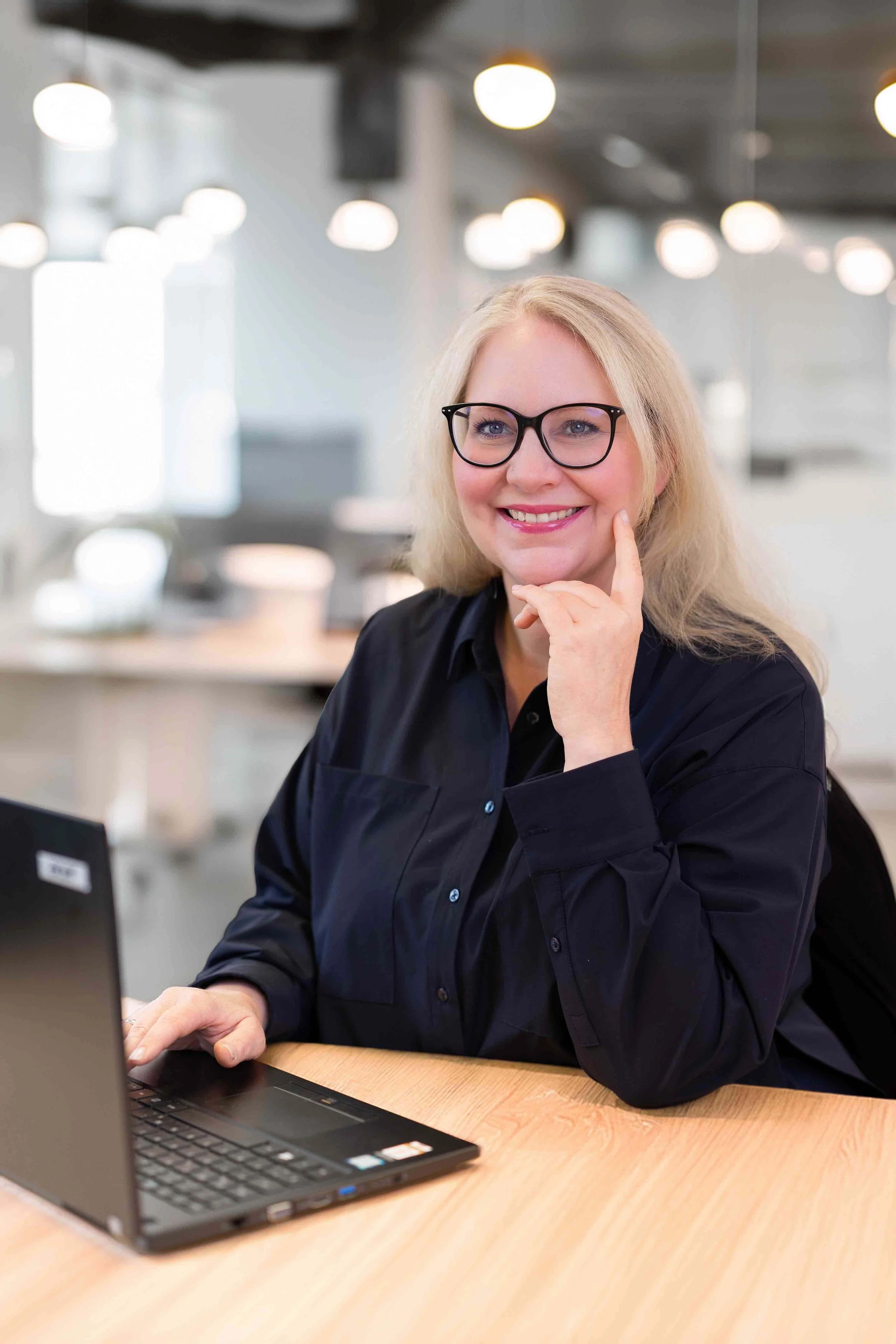 Business-Foto einer Blondine, die am Tisch sitzt und am Laptop arbeitet..jpg