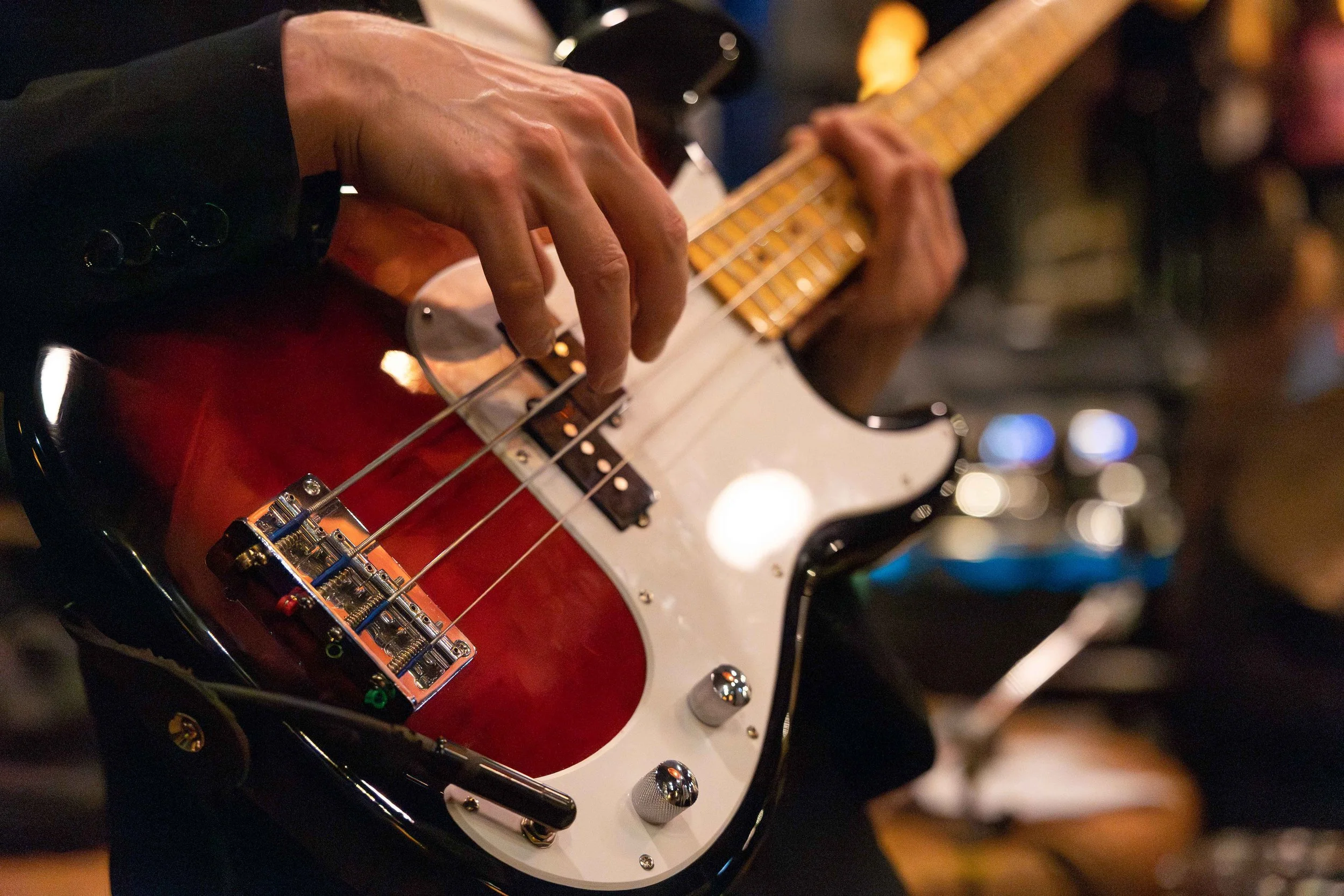 Foto einer Gitarre, auf dem auch die Hände des Mannes zu sehen sind, der darauf spielt.jpg