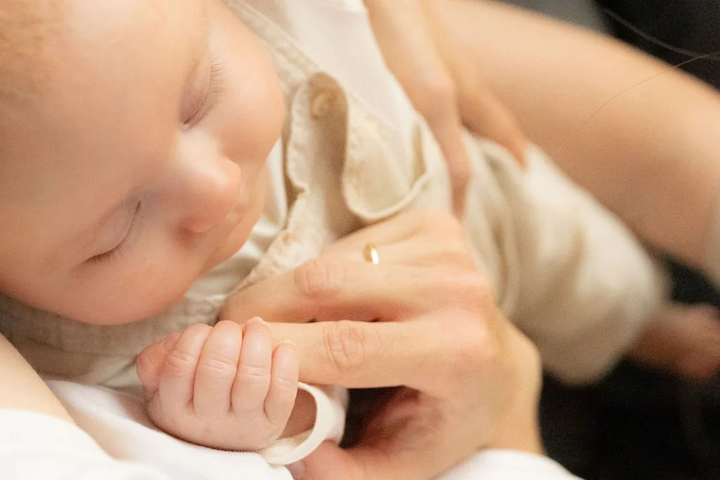 Das Baby hält mit seinem kleinen Händchen den Finger eines Elternteils fest..jpg