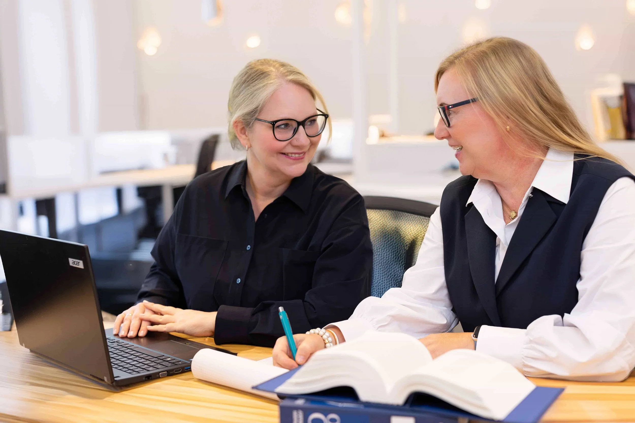 Business-Foto von zwei Frauen, die Notizen machen und sich ansehen..jpg