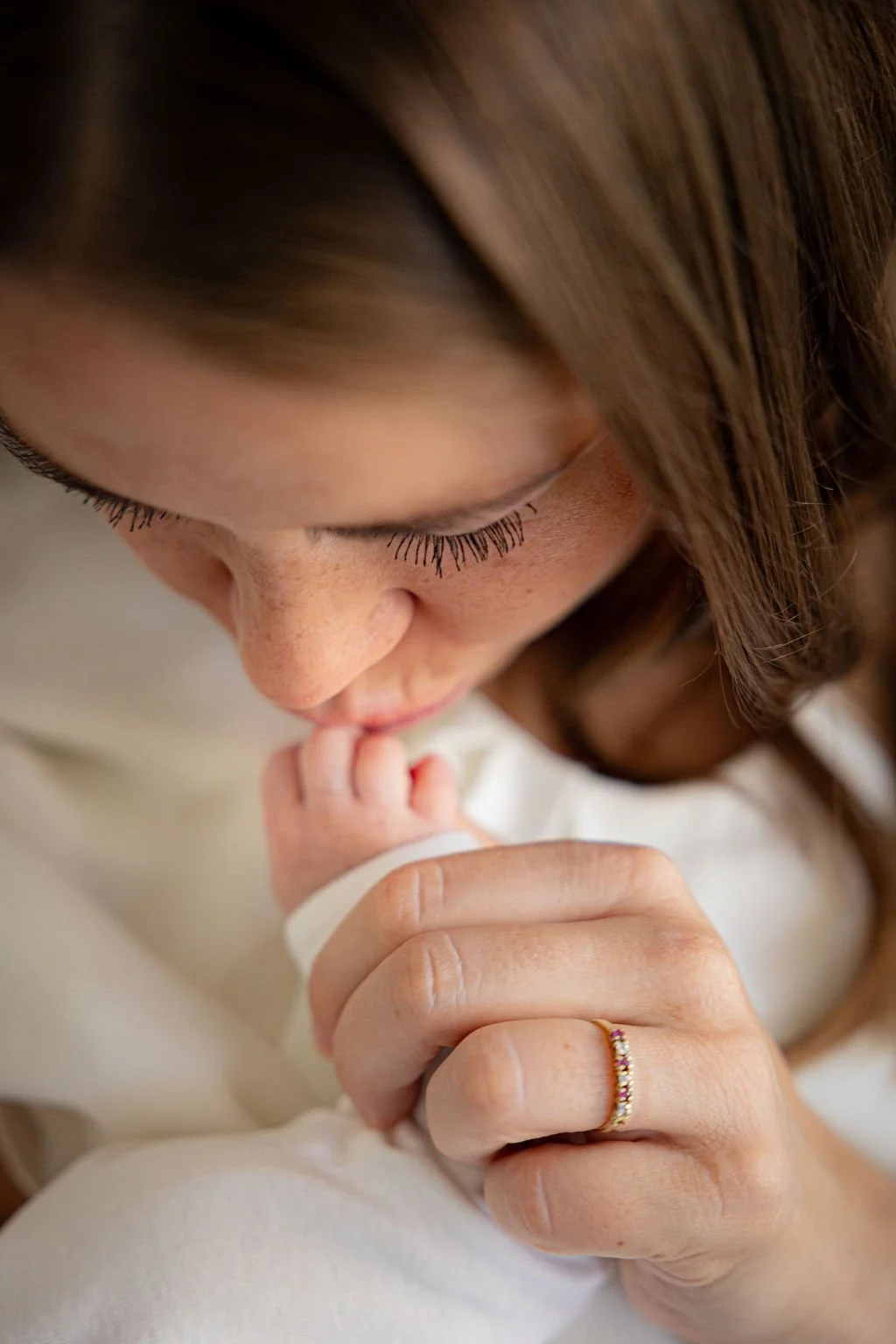 Die Mutter küsst das Händchen ihres Babys..jpg
