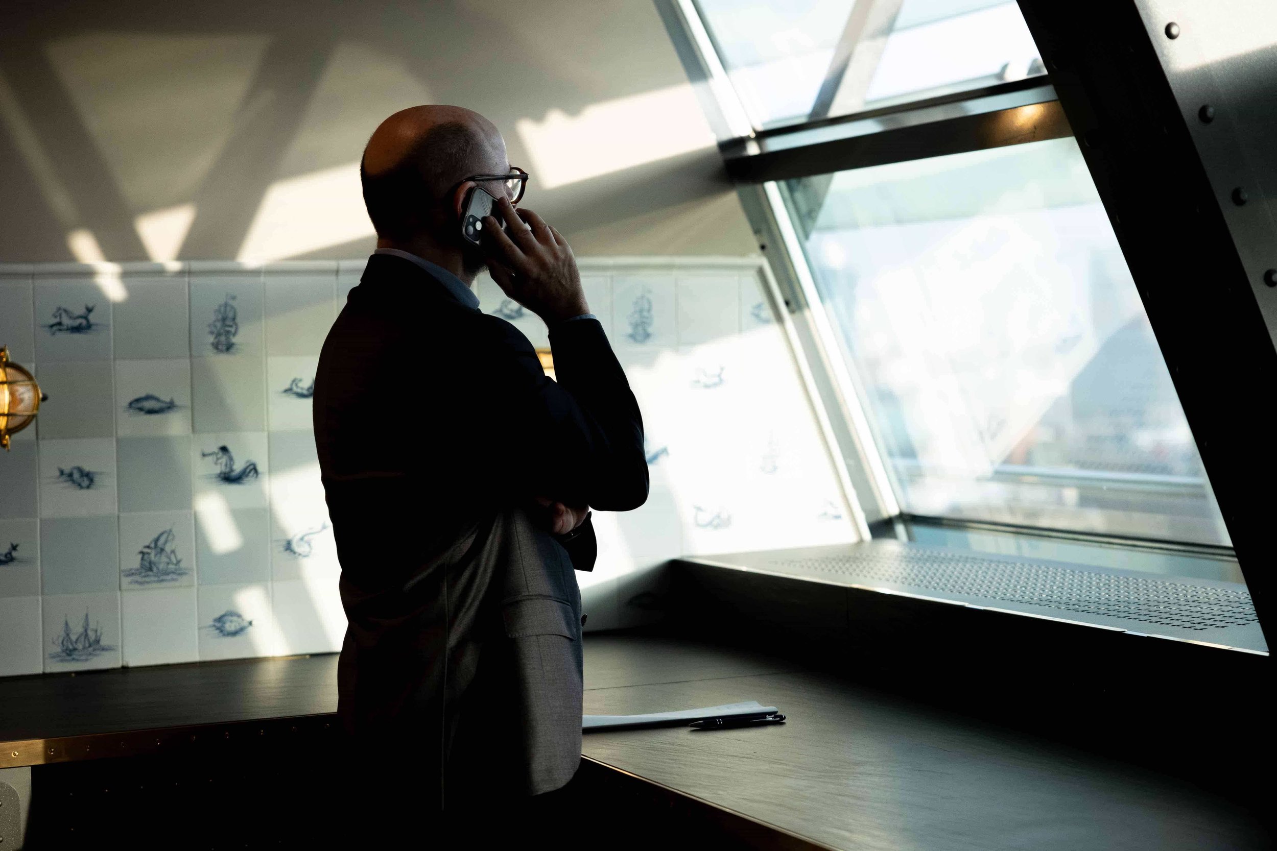 Business-Foto eines Mannes, der telefoniert und aus dem Fenster schaut..jpg