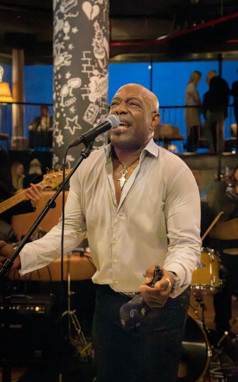 Ein Mann ist auf einer Veranstaltung und singt ins Mikrofon..jpeg