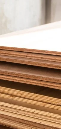 Close-up of several stacked sheets of plywood with different textures and thicknesses.