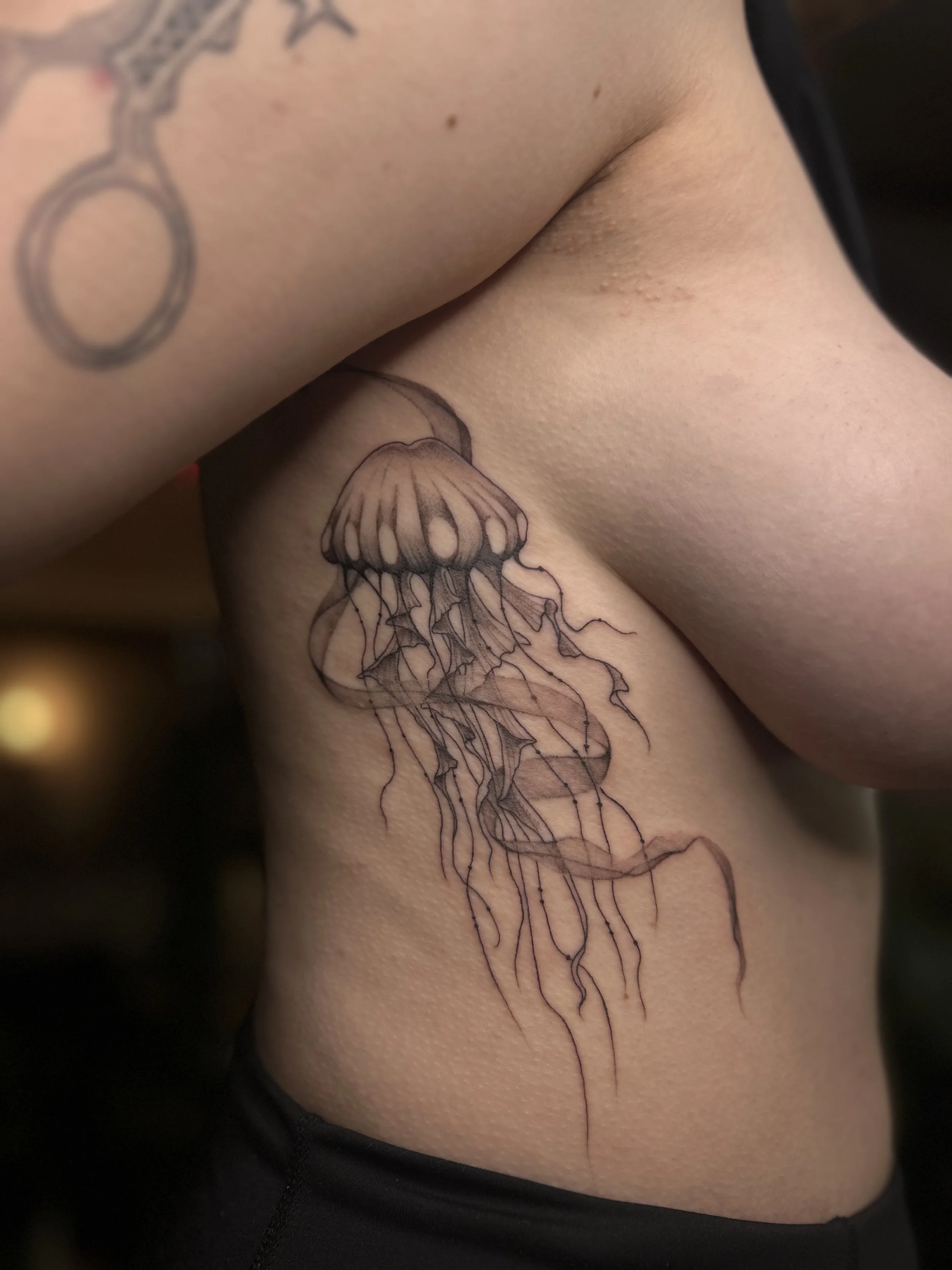 Tatouage de méduses sur le côté du corps d'une personne