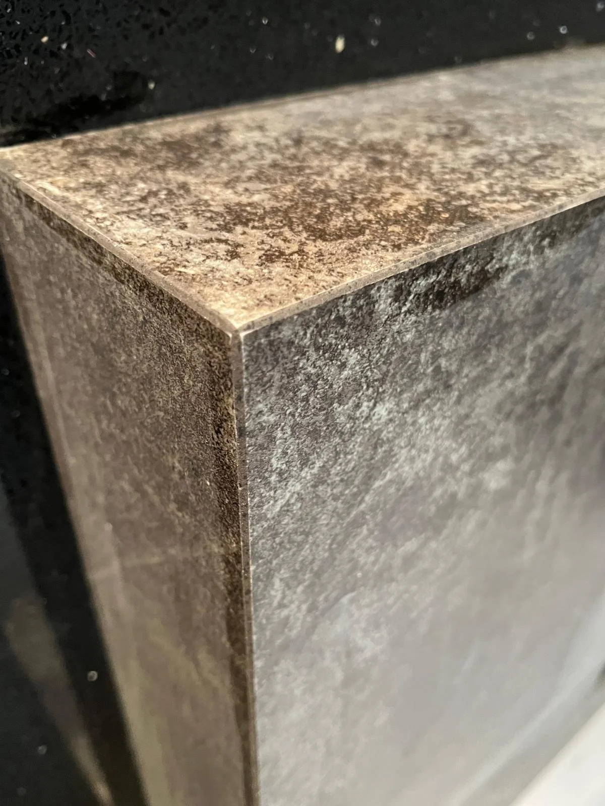 Nahaufnahme eines Gartensofas mit einem grauen, marmorierten Steinboden