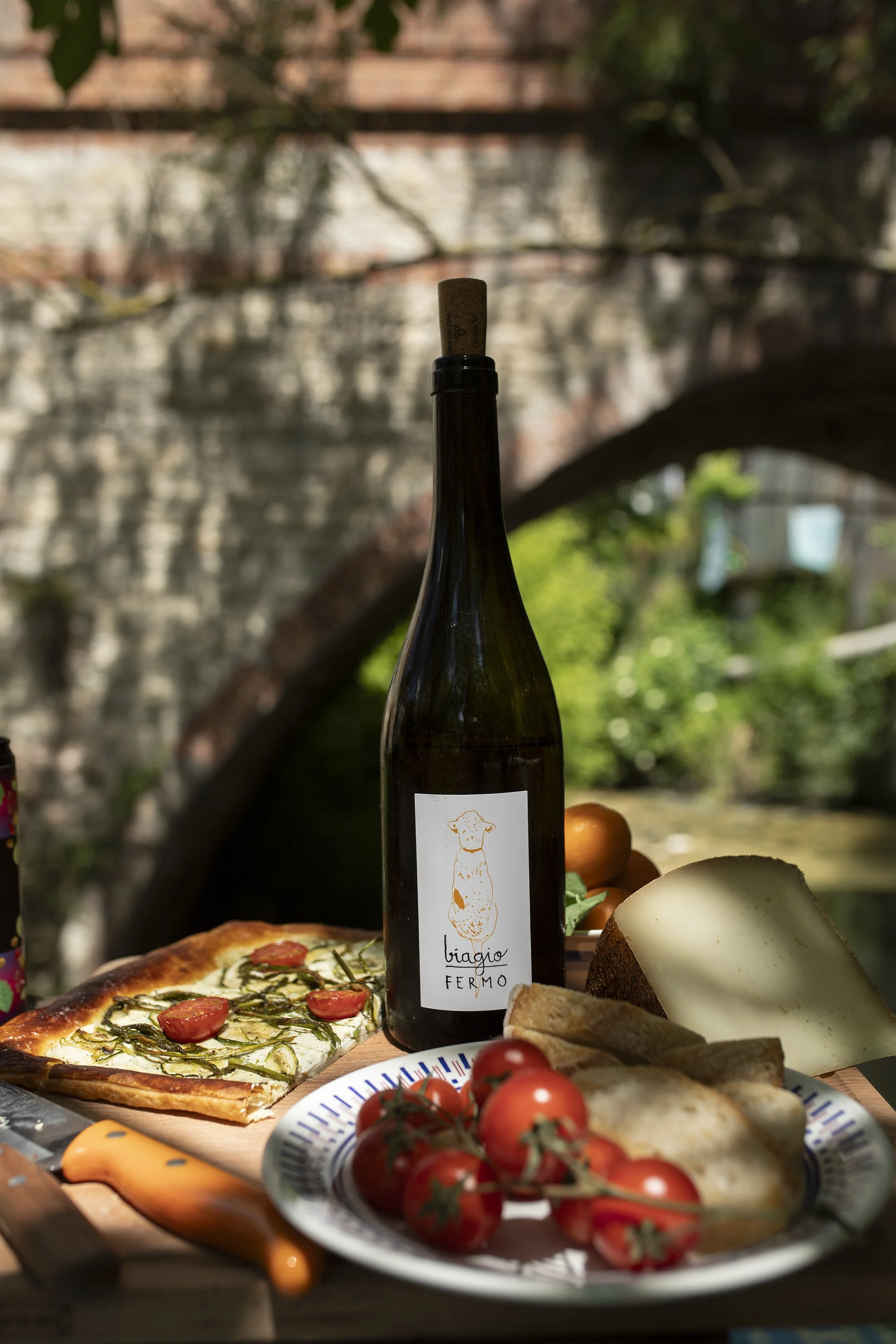 image of san biagio bottle of wine in the orto with pizza and the bridge