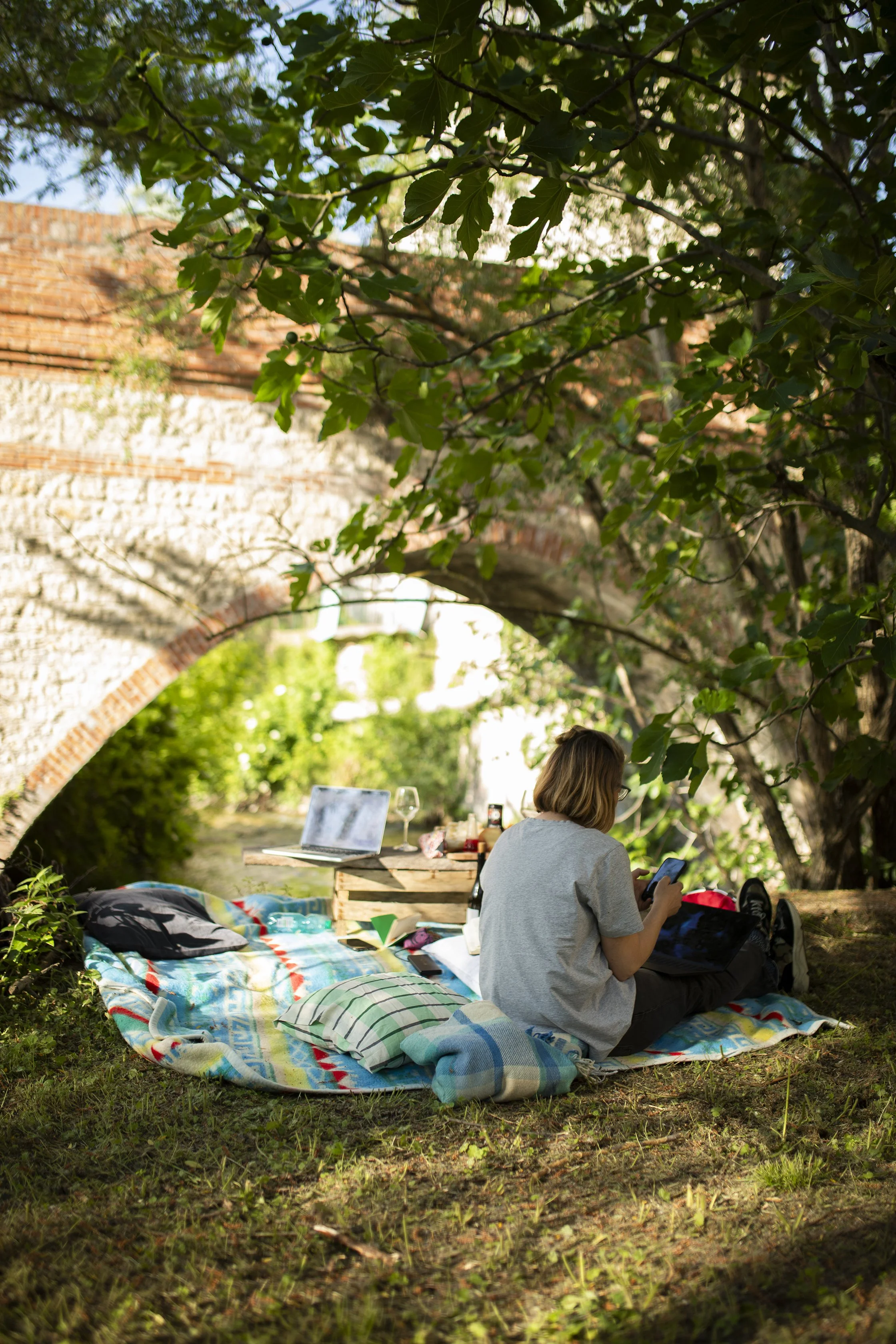 image of smart working in the orto with the bridge in the background and a glass of wine