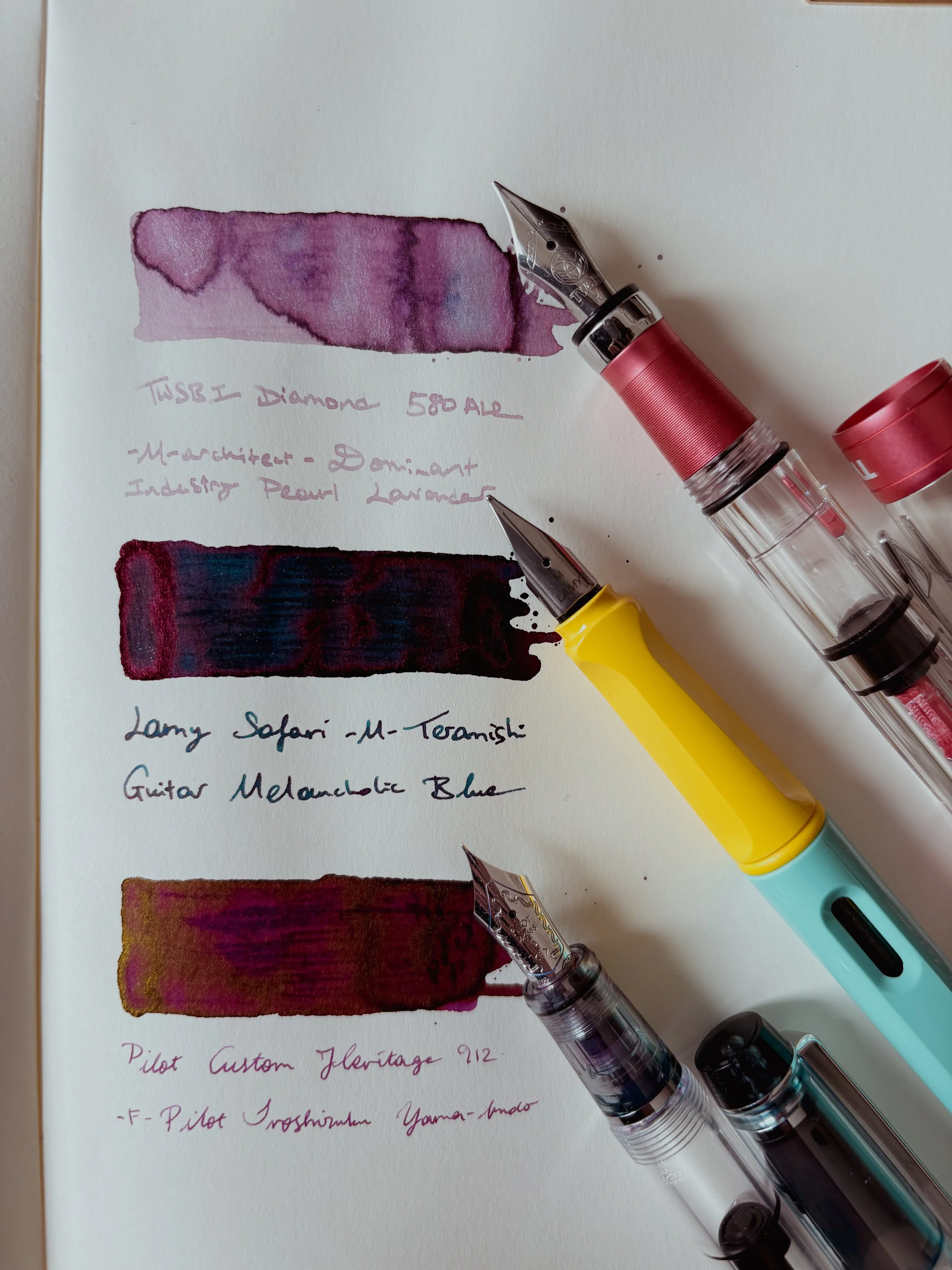Three fountain pens with ink swatches.