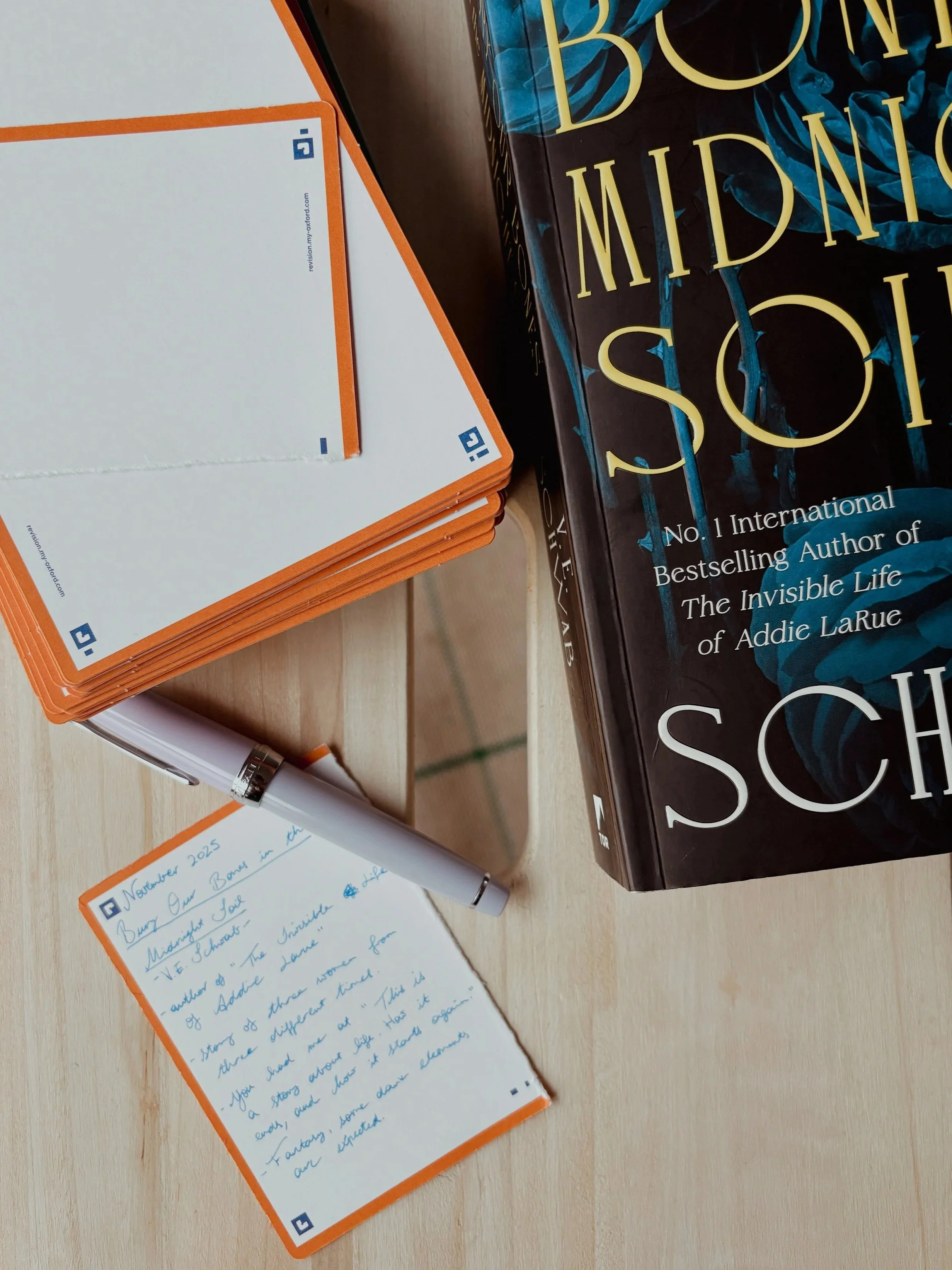 A novel, Oxford branded flashcards, a fountain pen and a book commentary in scene.