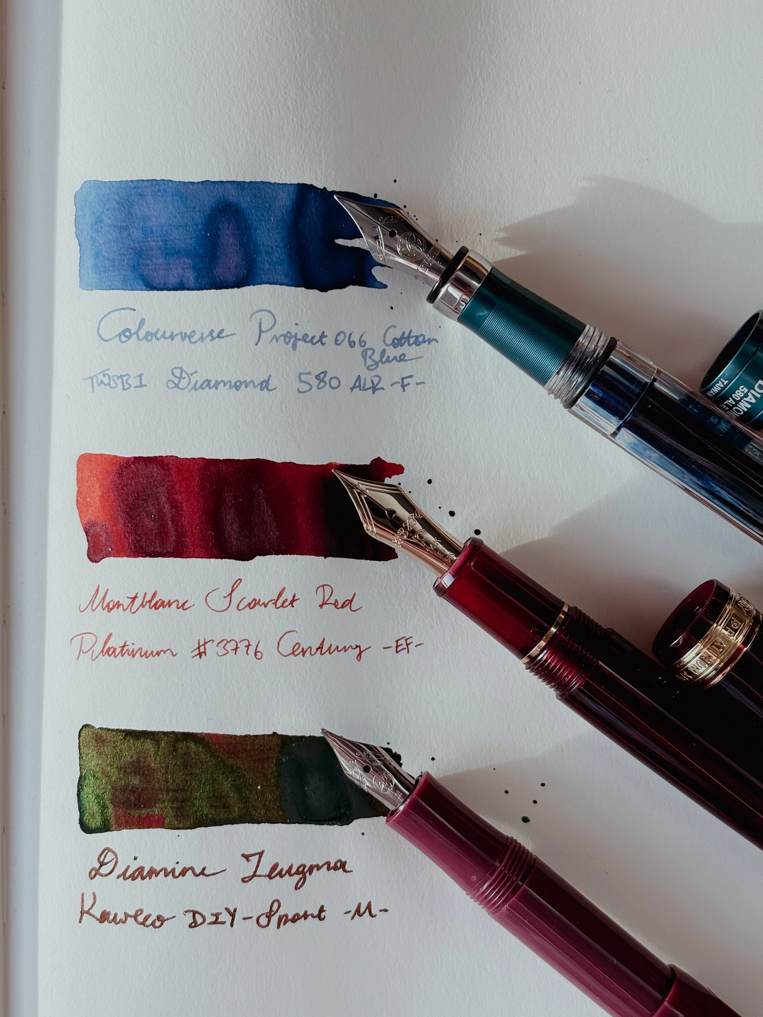 Three fountain pens with ink swatches.