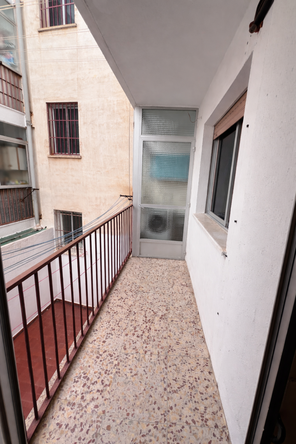 Balcón urbano con puerta acristalada.png