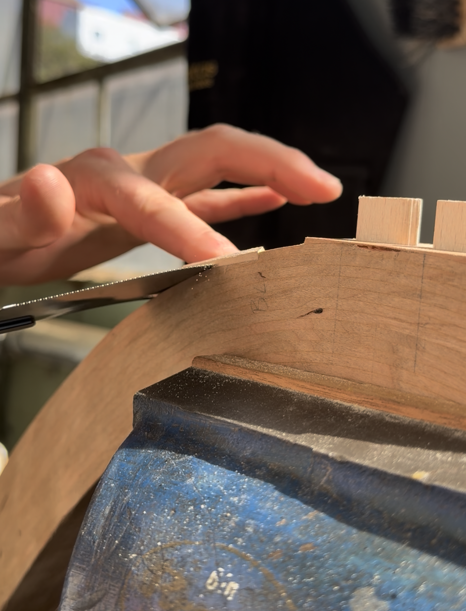 Close-up of a woodworker carving a groove by hand with a chisel