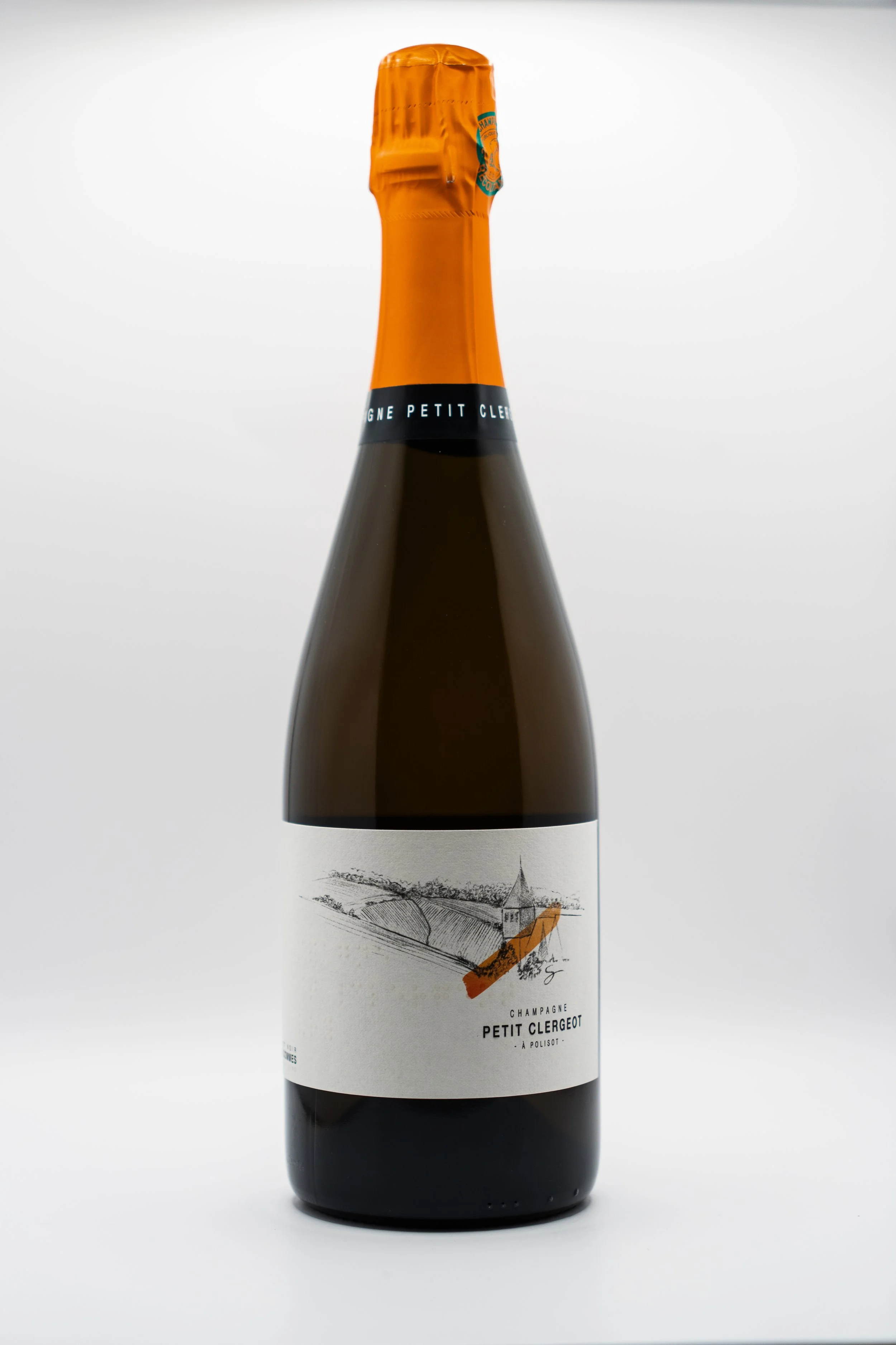 Bouteille de champagne Petite Clergé avec une étiquette illustrée d'un dessin en noir et blanc d'une maison ou un bâtiment avec un paysage environnant, le tout sur un fond blanc.