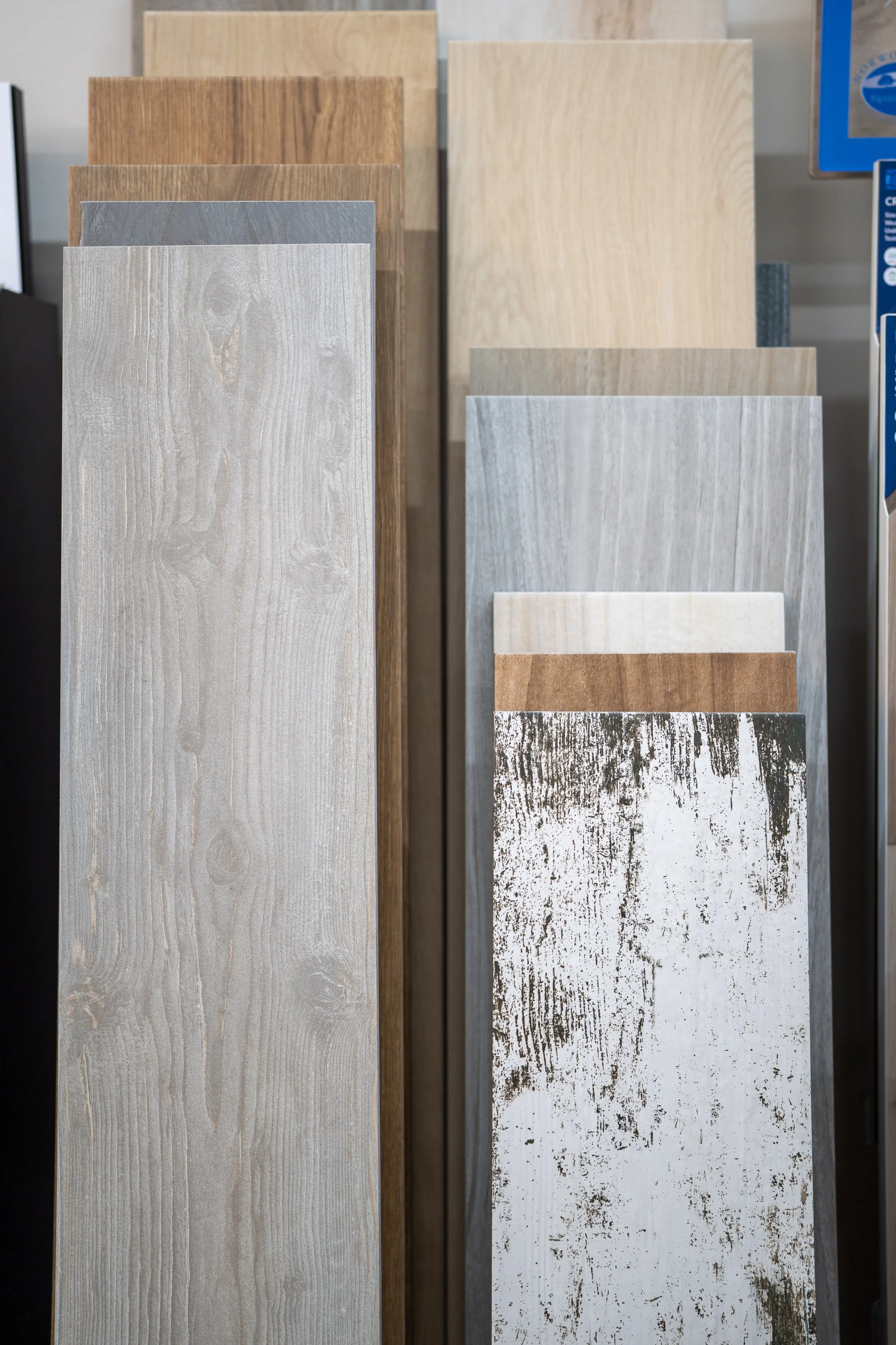 Display of various wood grain tile samples in different colors and textures at Seamless Floors showroom located in St Augustine.