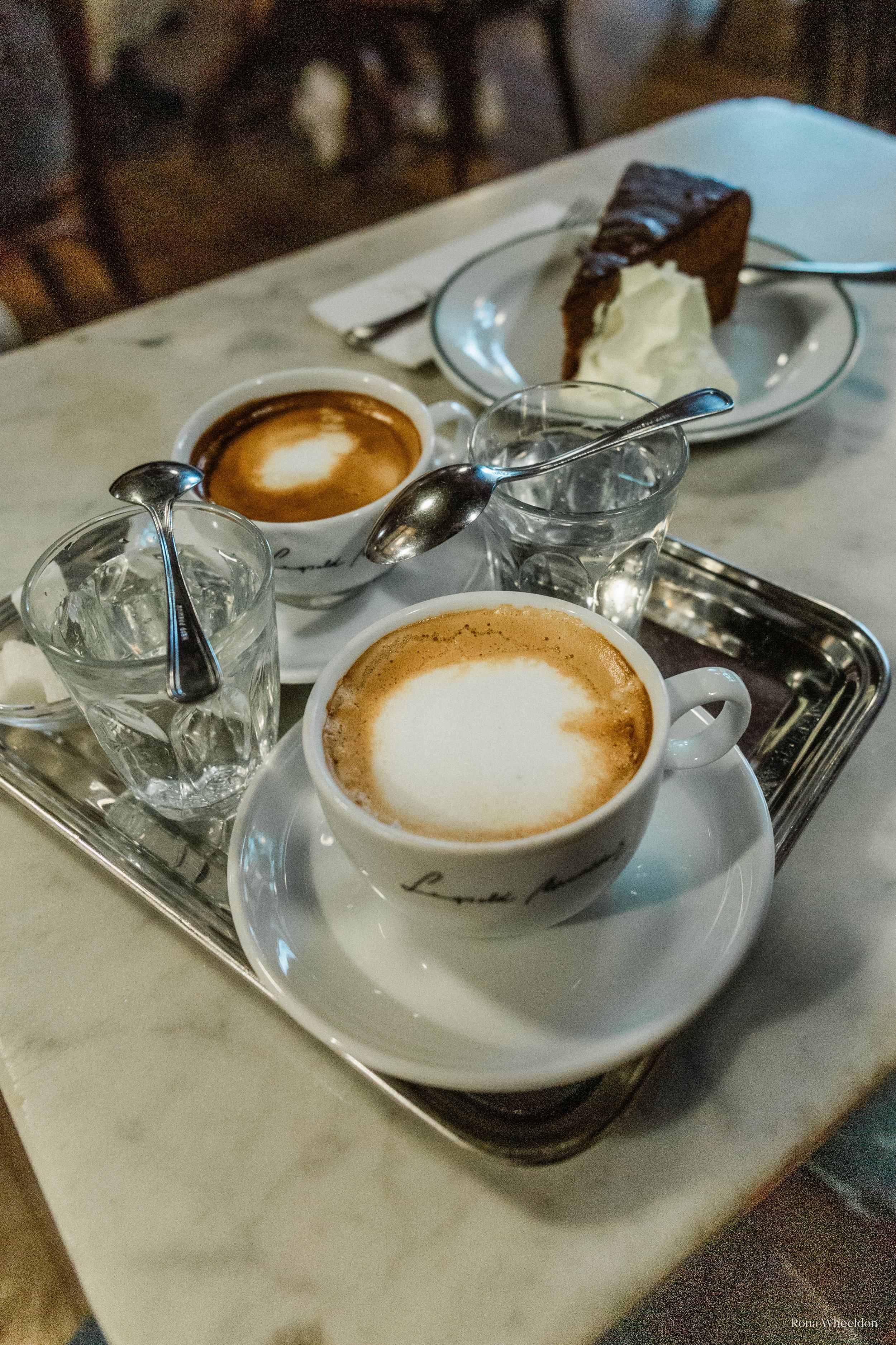 Viennese coffees, glasses or water and teaspoons