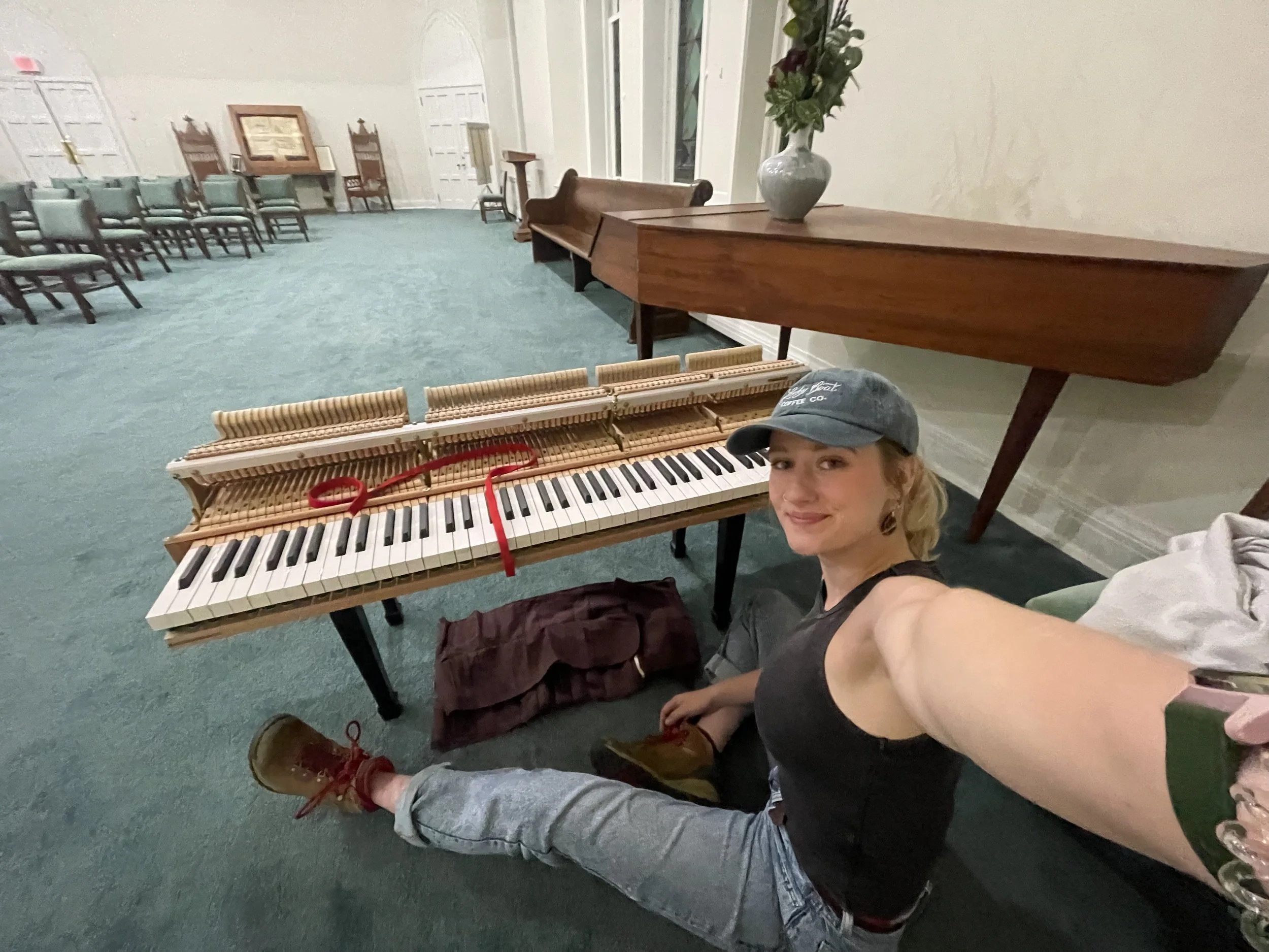 An upright wooden piano with the lid open, exposing the strings and mechanisms inside. The brand name 'Schimmel' is visible on the front.