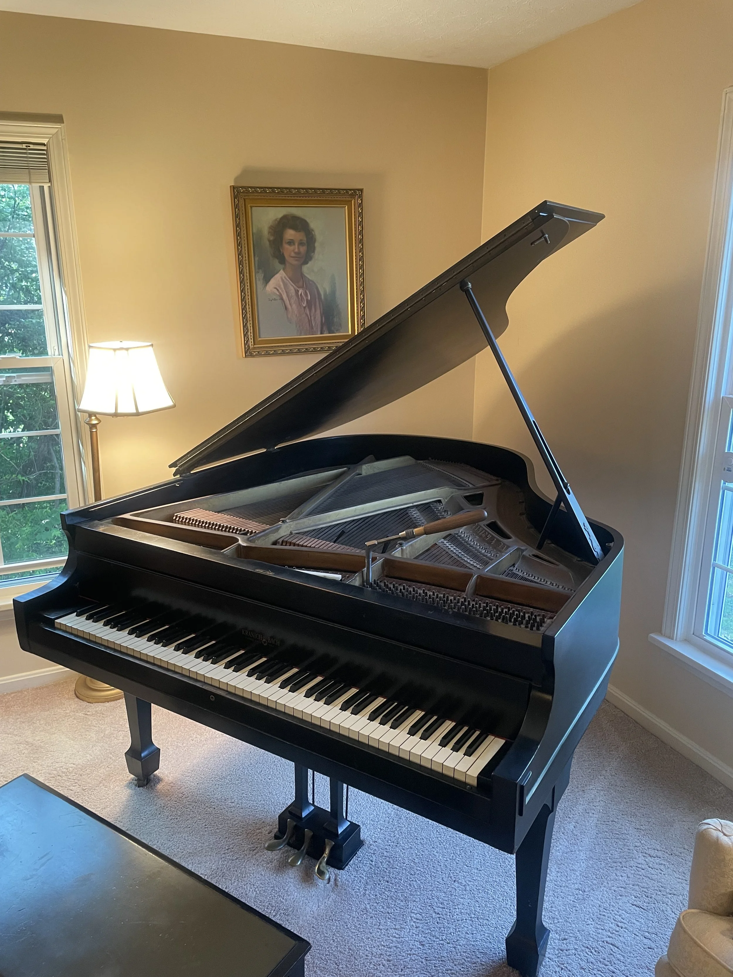 Tuning an antique grand piano, dated to the 1920s
