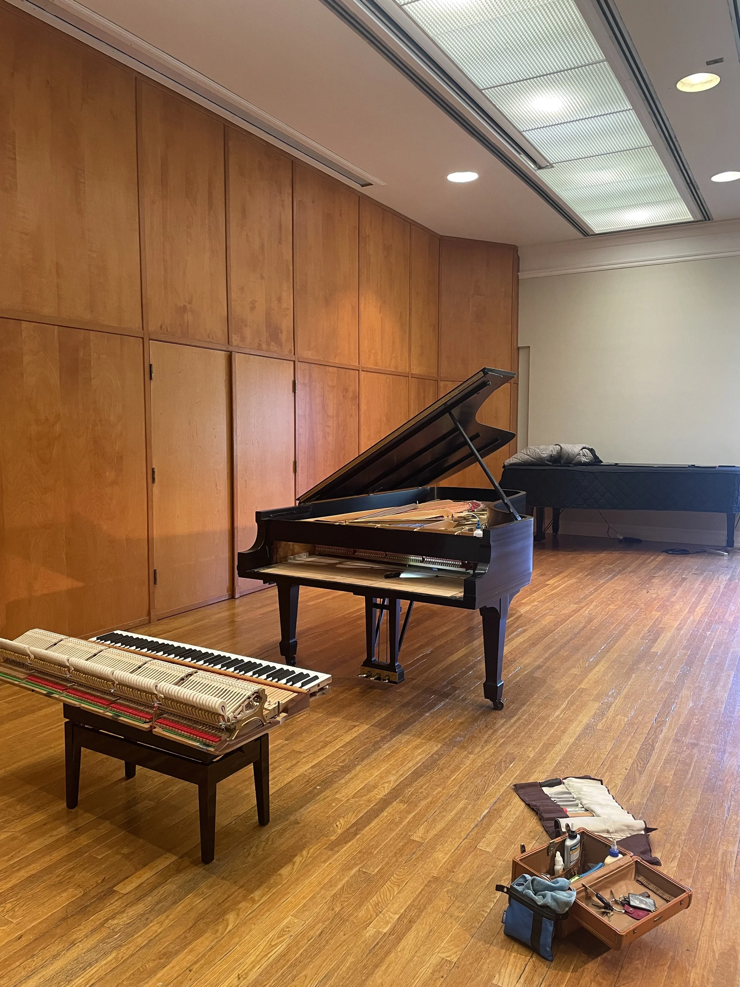 A Steinway Model D being prepared for a performance in a recital hall