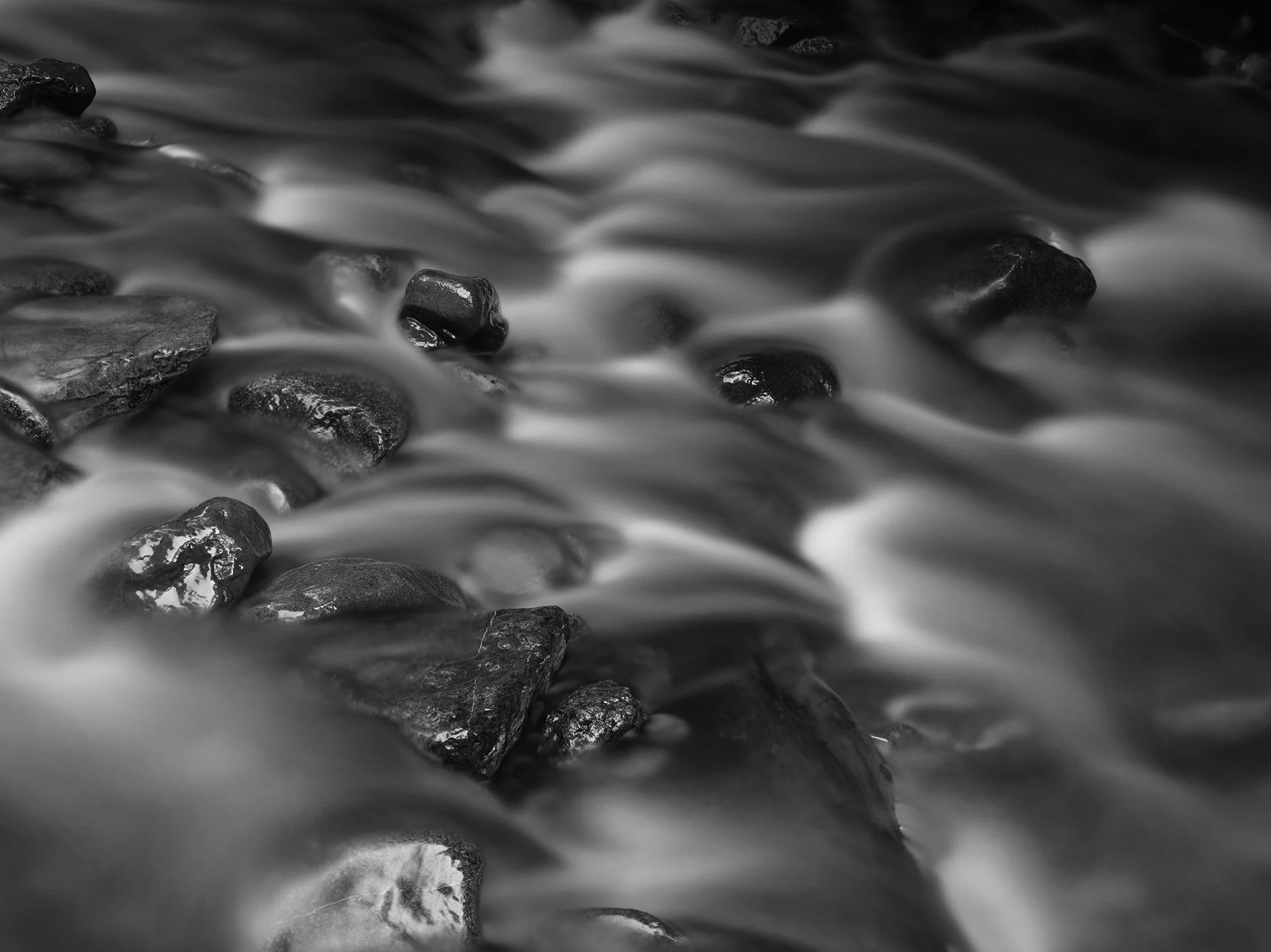 Black and white photo of water flowing over rocks.