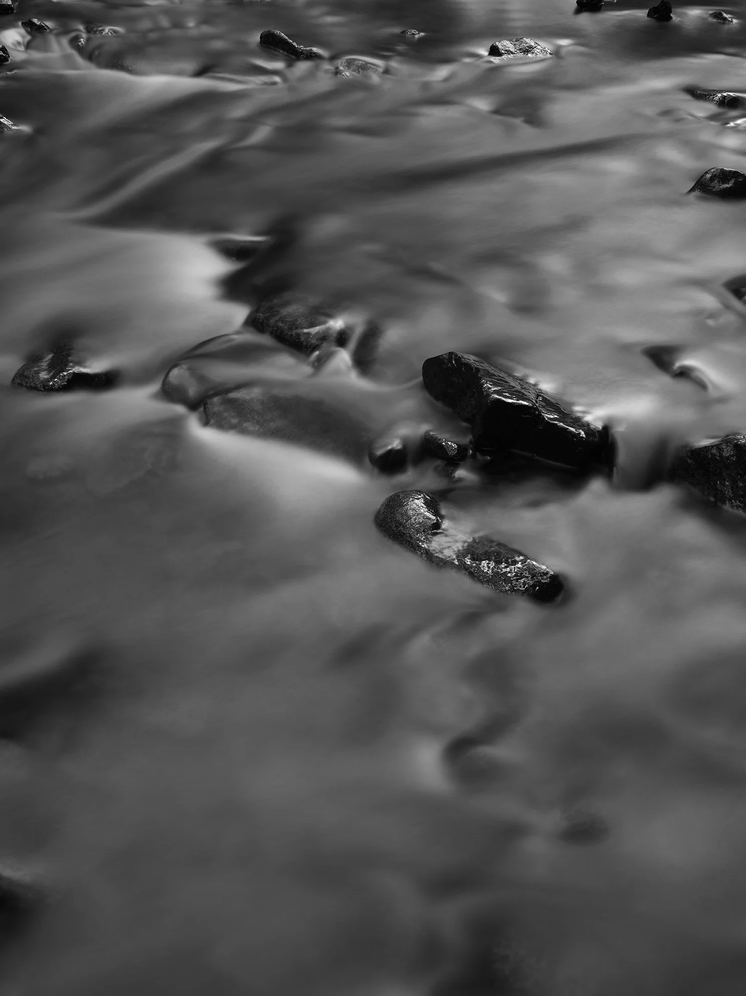 Black and white photo of water flowing over rocks.