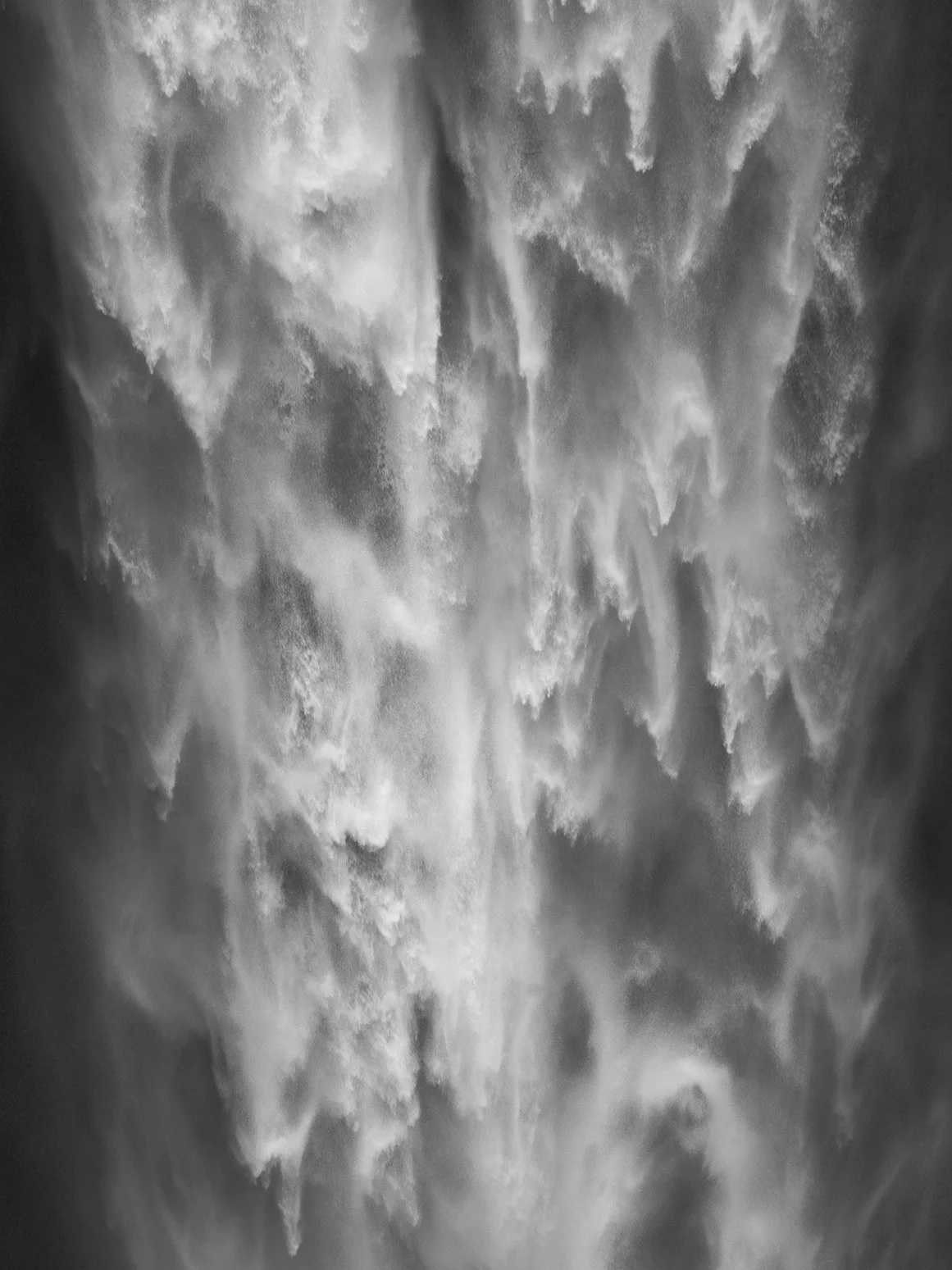 Close-up view of falling water, creating a misty effect with bubbles and foam.