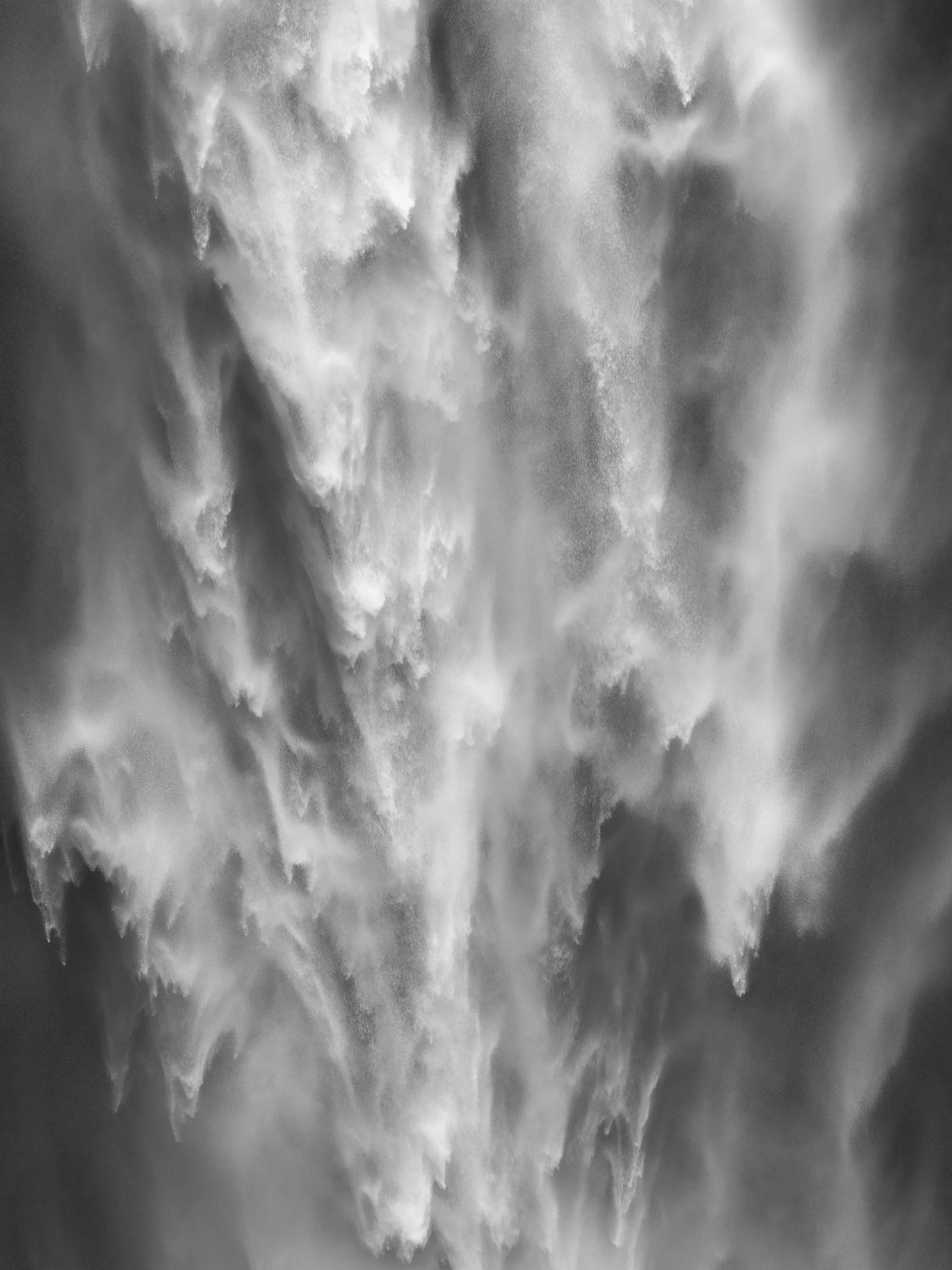 Black and white photo of a crashing ocean wave.